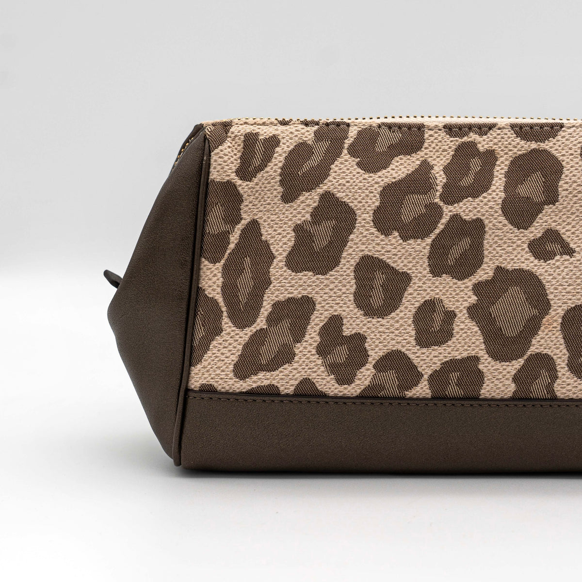 Coach cosmetic pouch in brown and beige leopard print canvas with chocolate leather trim and gold hardware, shown with wrist strap.