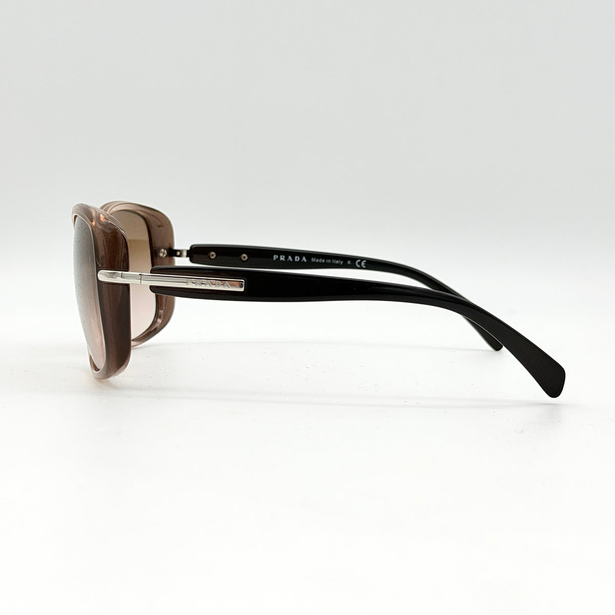 Prada SPR080 sunglasses featuring a brown and blush oversized frame with gradient lenses and silver hardware at the temples.