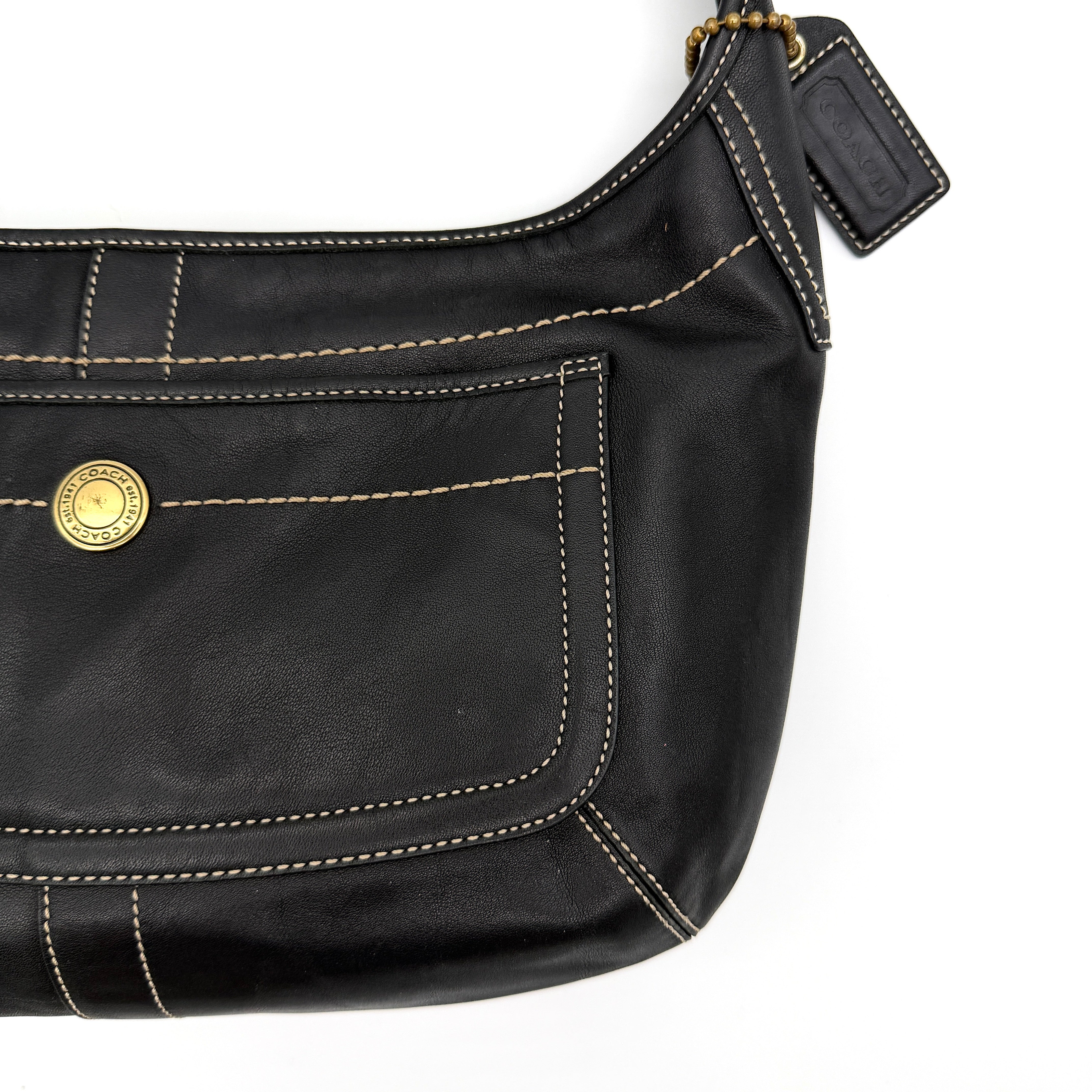 Coach Signature Ergo Hobo Shoulder Bag in black leather with contrast stitching and brass hardware, displayed against a white background.