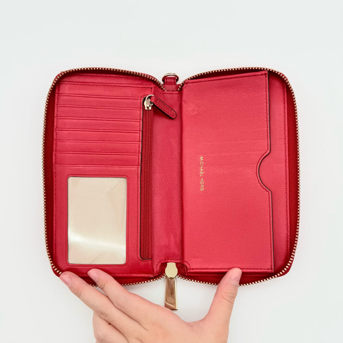 Front view of the Michael Kors red quilted large wallet with gold zip and MK monogram stitching.