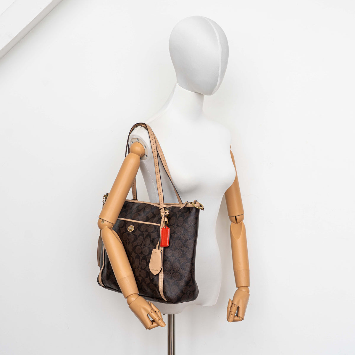 Coach Signature Peyton Pocket tote bag in brown canvas with tan leather trim, shown with both handles and detachable strap.