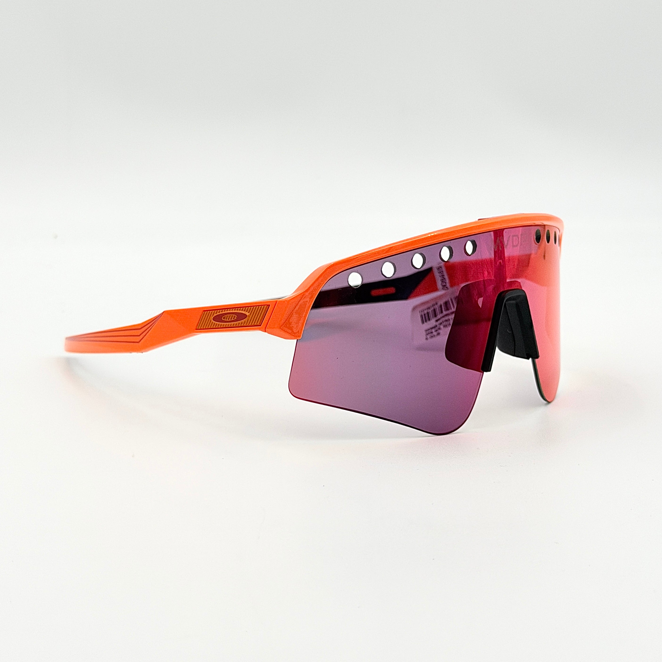 Oakley Sutro Lite Sweep MVDP Prizm Road sunglasses in orange sparkle with a shield lens and original pouch, photographed in bright studio lighting.