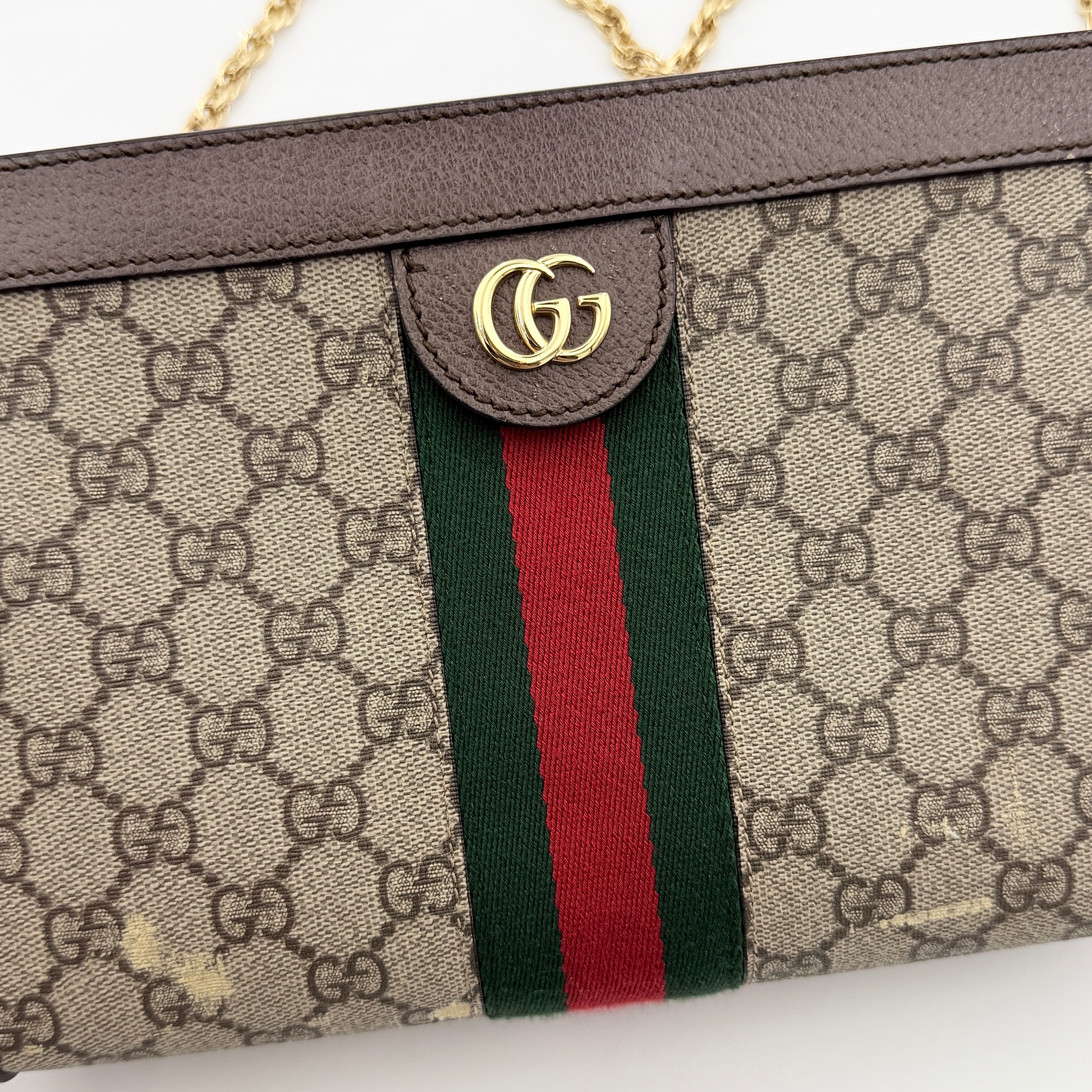 Gucci Ophidia GG Supreme crossbody bag in beige canvas with brown leather trim, signature web stripe, and gold chain strap.