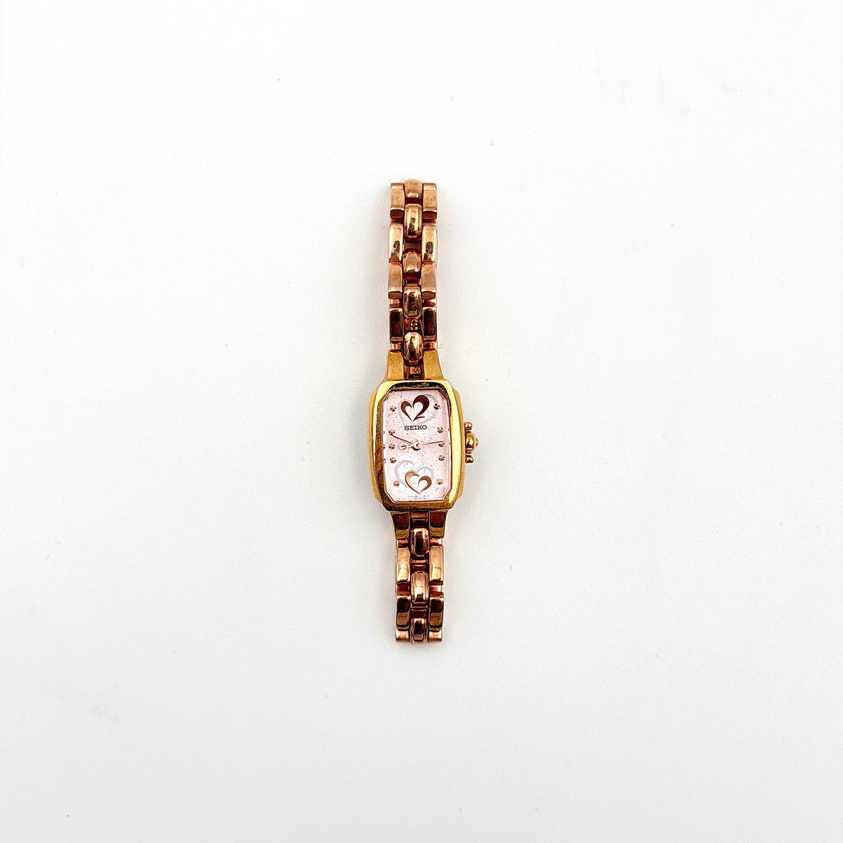 Front view of the Seiko Tisse Nozomi Special Edition watch with a pink heart motif dial and two-tone gold and rose gold bracelet.