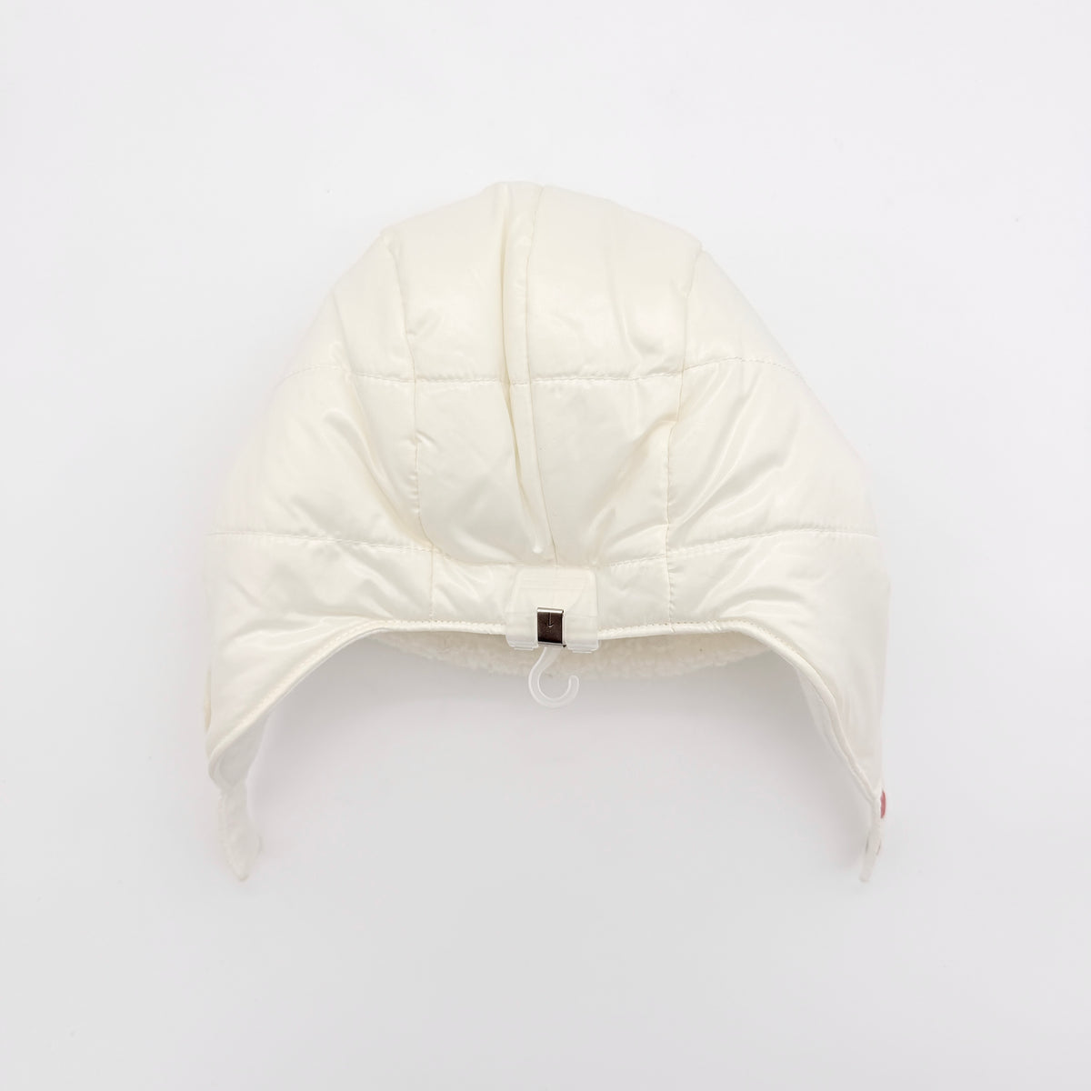 Moncler ivory quilted trapper hat with plush faux fur trim and signature logo patch displayed on white background.