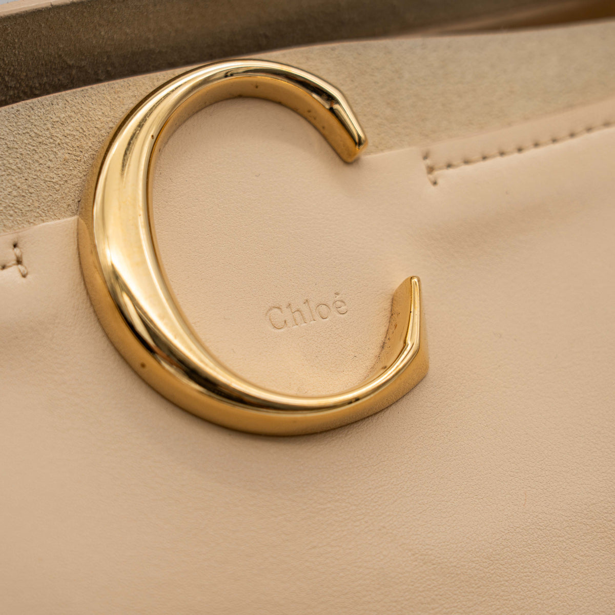 Chloé C Zipped Tote Bag in beige leather with gold hardware, shown with structured dual straps and front logo detail.