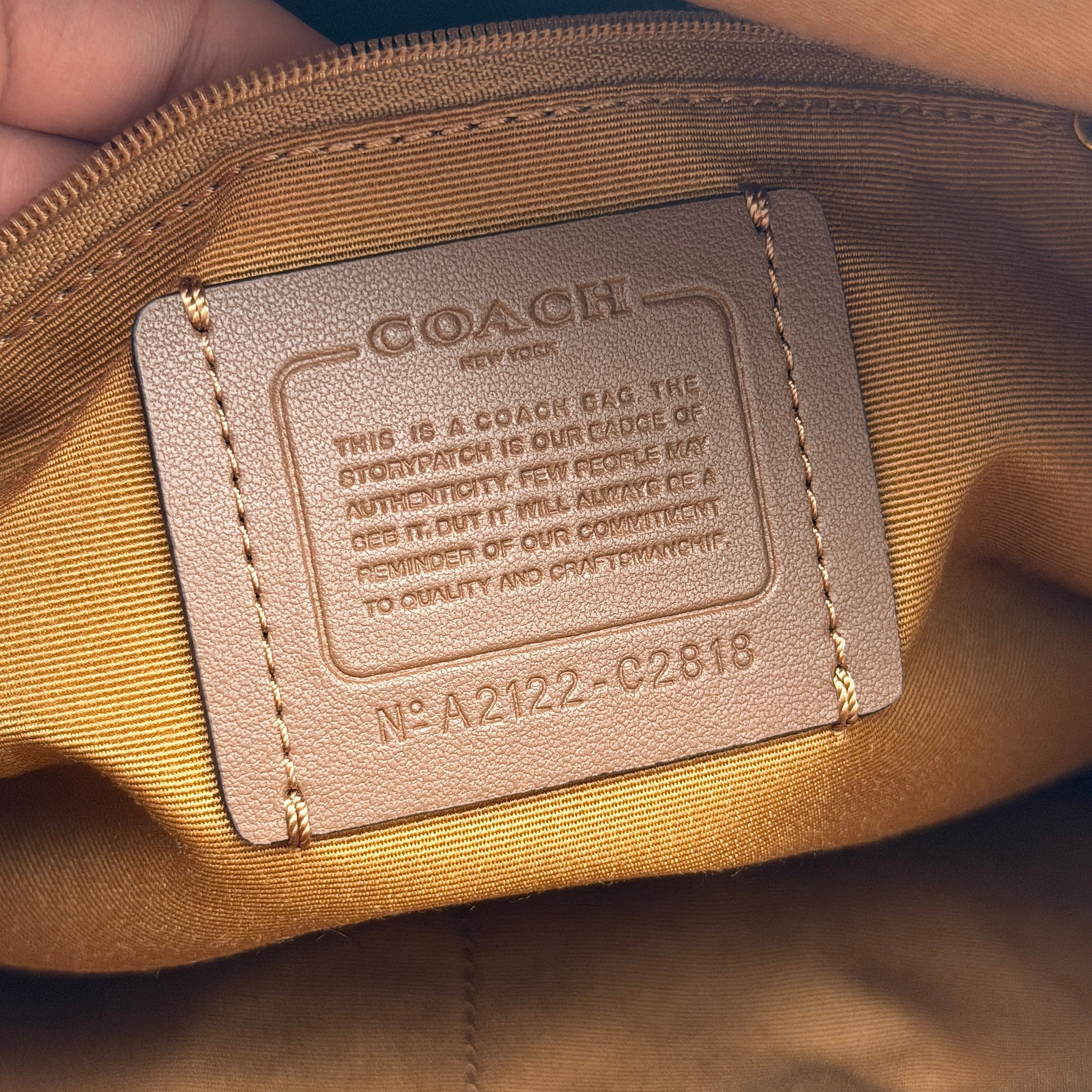 Coach Ellie File Crossbody Bag in ivory pebbled leather with gold hardware and adjustable strap, displayed on a white background.