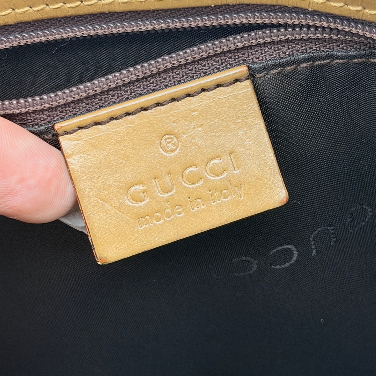 Front-facing Gucci GG Monogram Tote Bag in beige canvas with brown leather trim and double handles.