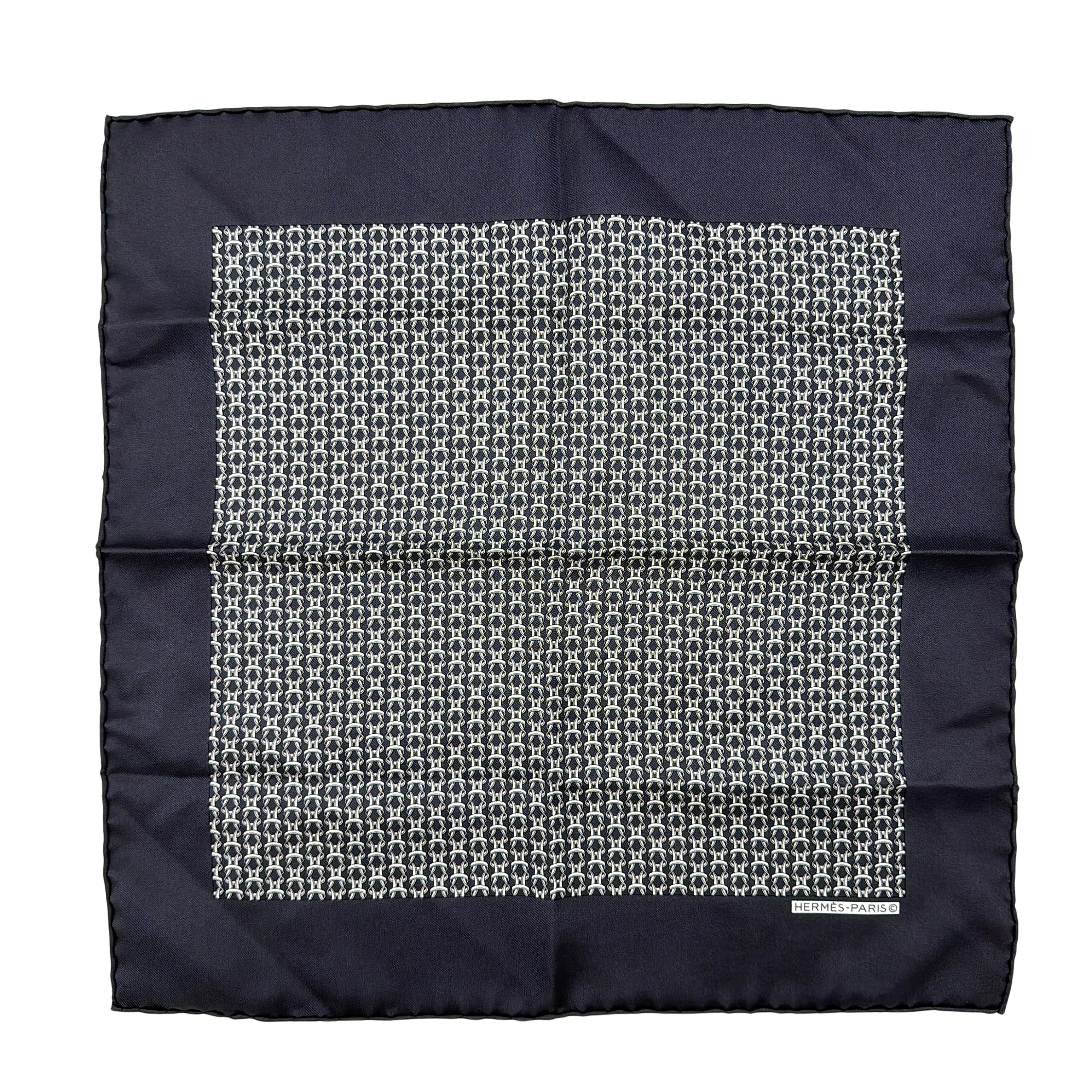 Hermès silk scarf in navy blue with a white chain link pattern and bold border, elegantly displayed flat.