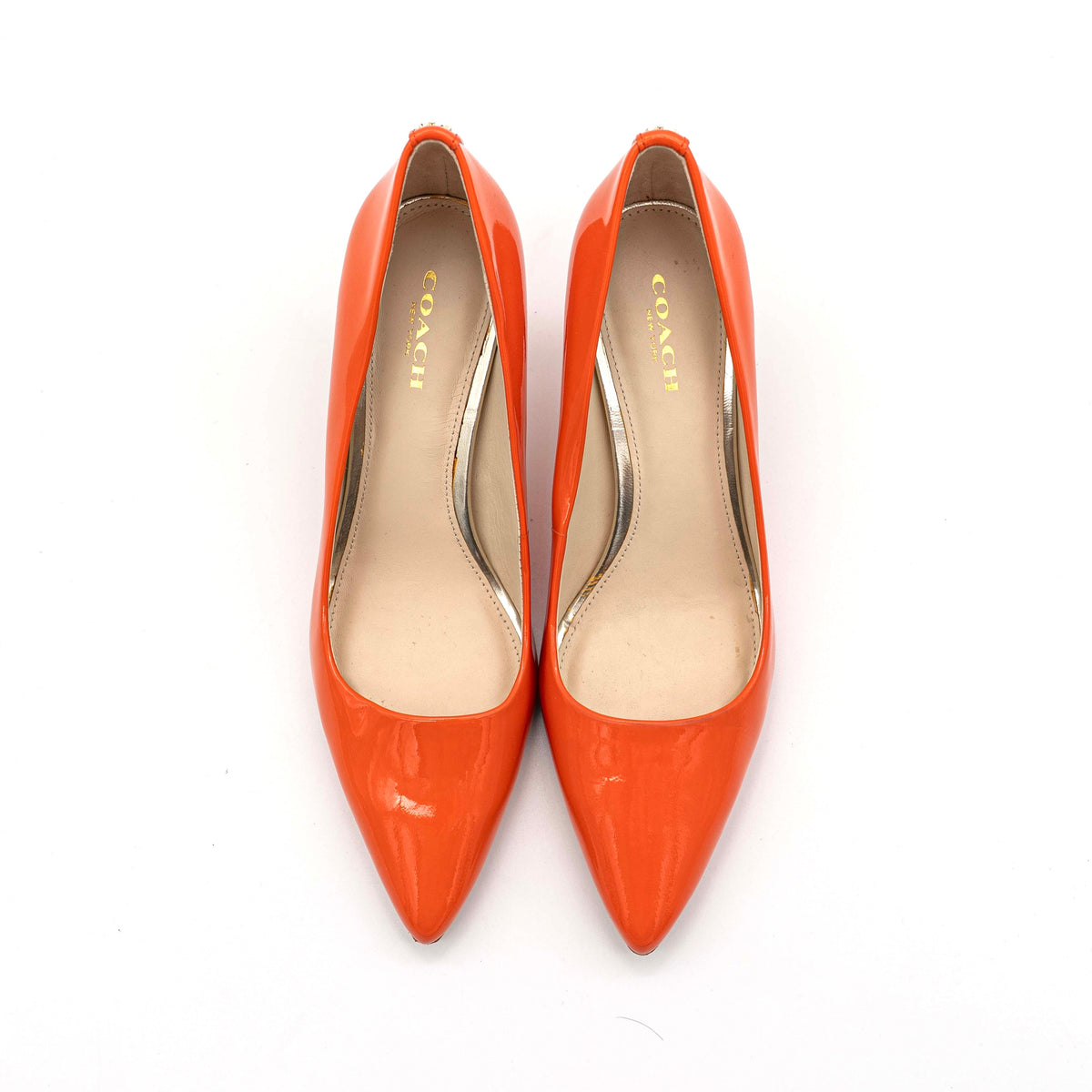 Pair of Coach orange patent leather pointed-toe heels with gold logo detail, size EU 35.5.