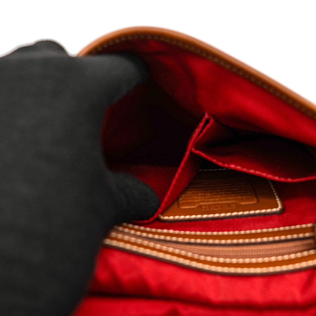 Coach signature denim hobo crossbody bag with red and blue stripe, brown leather trim, and an adjustable strap.