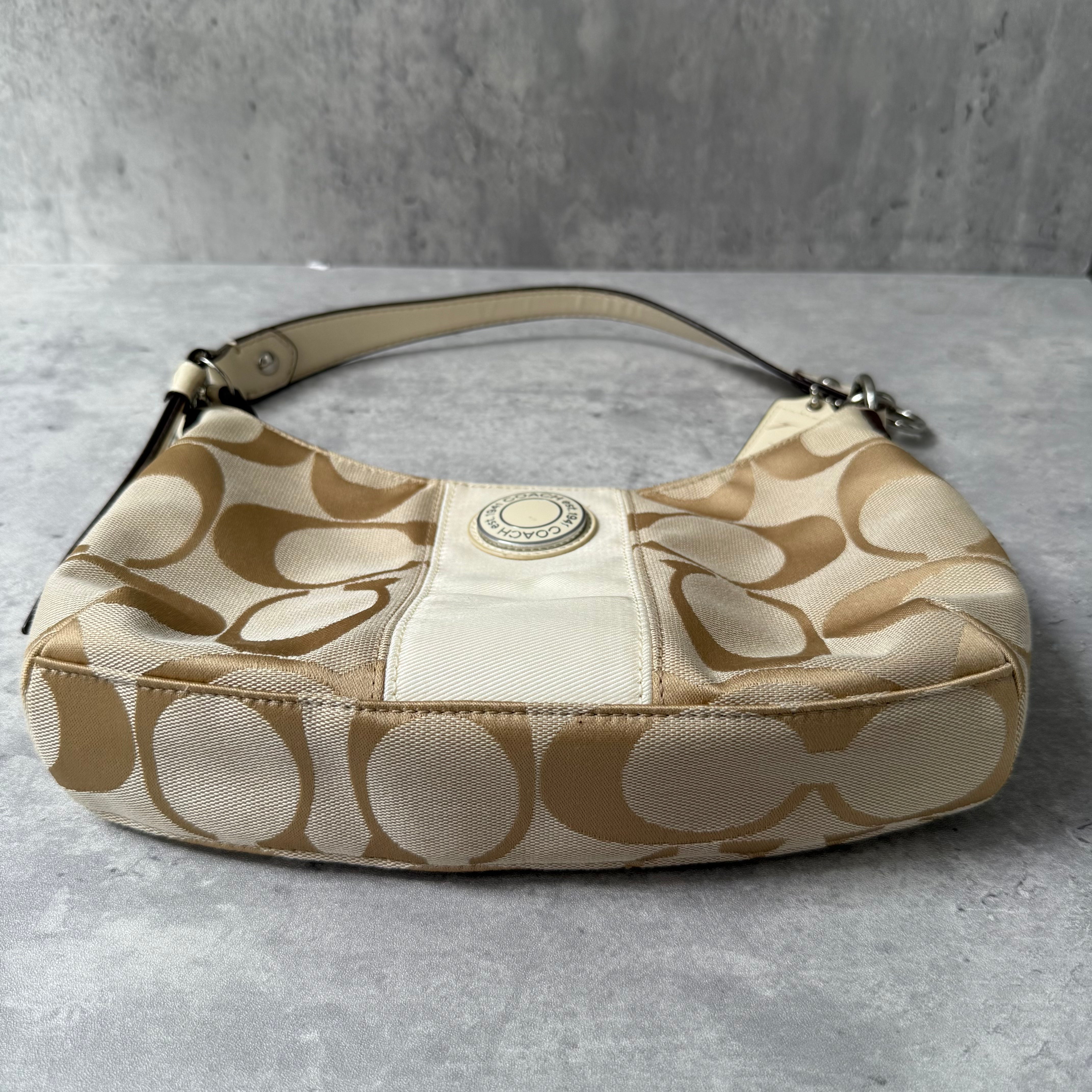 Coach 2-Way Signature Stripe Shoulder Bag in Beige and White with detachable strap, zip closure, and central white leather stripe with metal Coach emblem