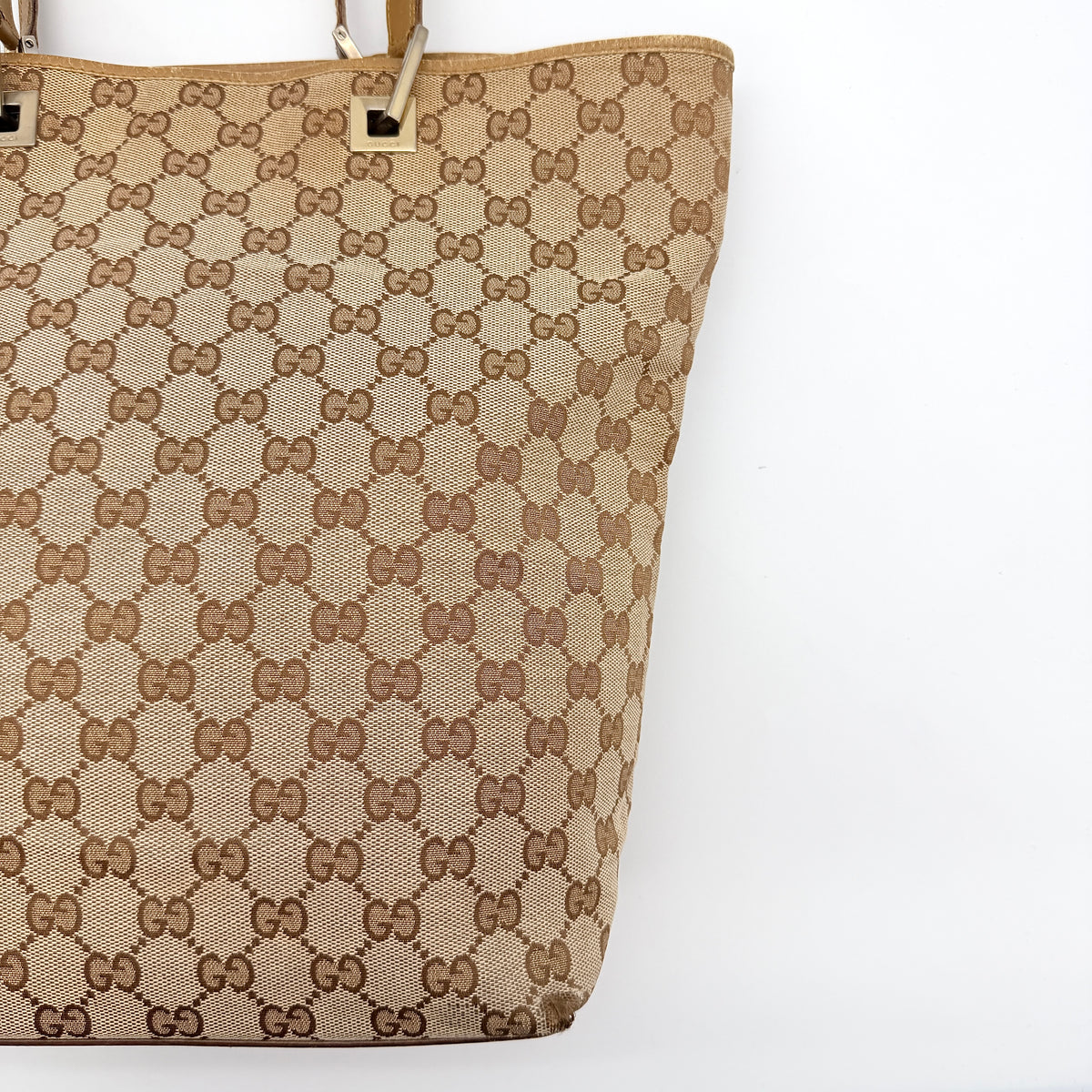 Front-facing Gucci GG Monogram Tote Bag in beige canvas with brown leather trim and double handles.