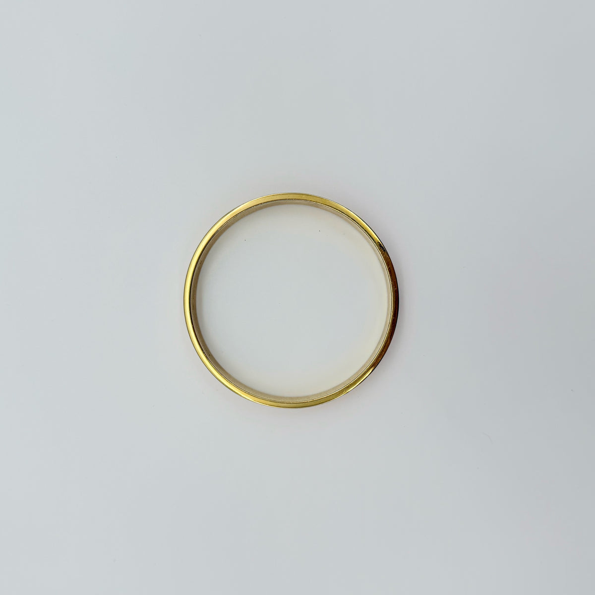Kate Spade New York enamel bangle in orange with gold-tone interior and logo detailing, photographed on a white background.