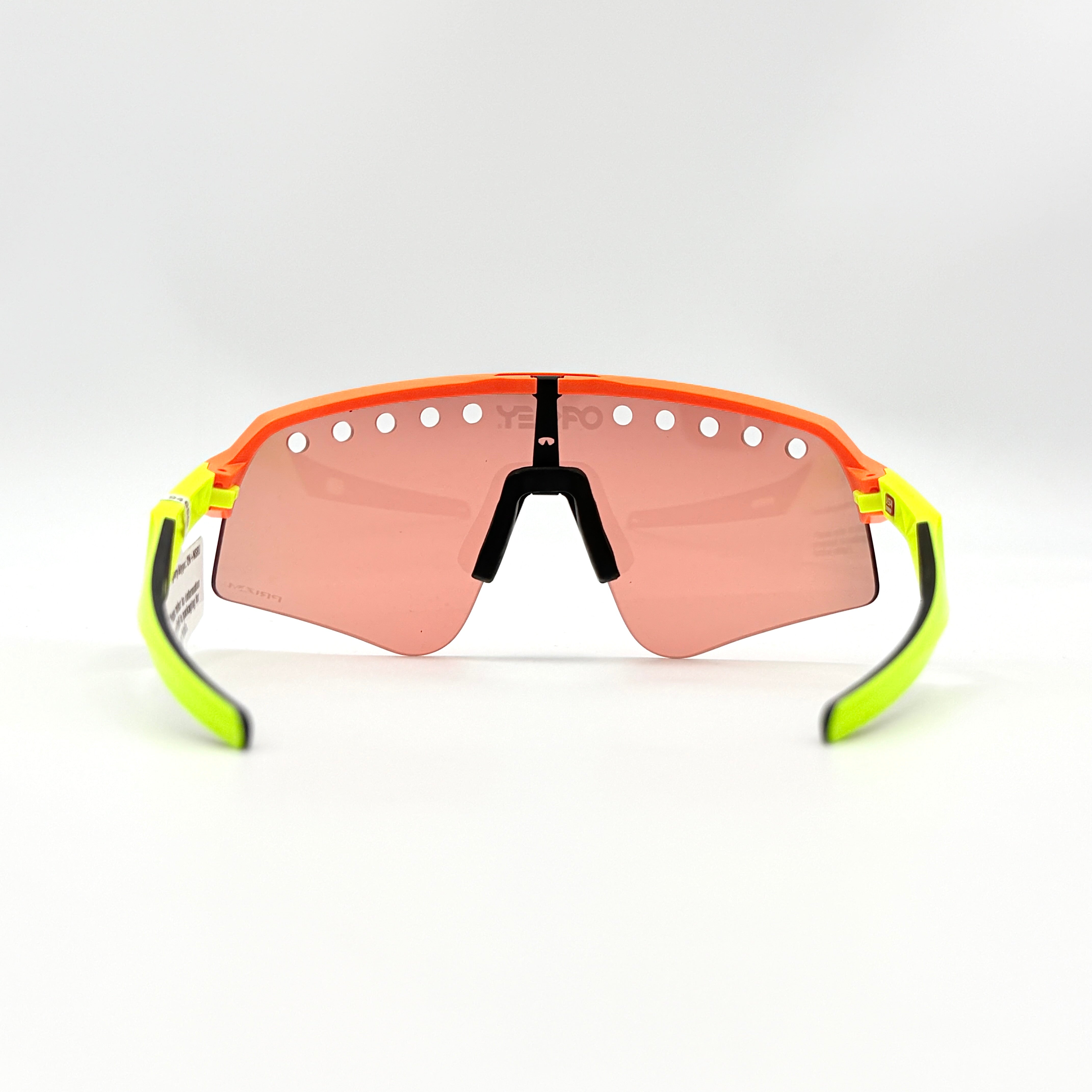 Oakley Sutro Lite Sweep sunglasses in neon yellow and orange with Prizm Trail Torch shield lens, displayed with box and case.