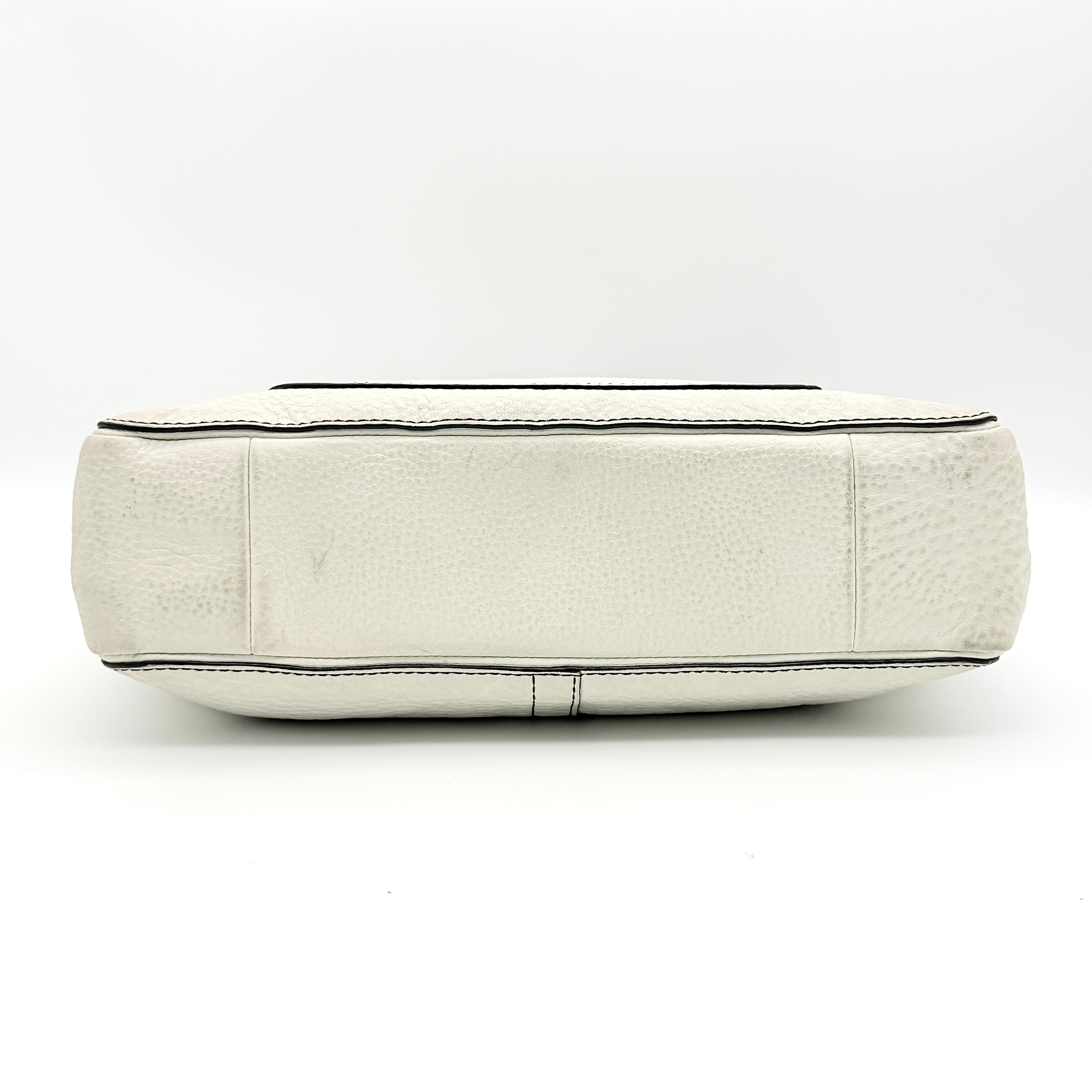 Coach Chelsea Shoulder Bag in ivory leather with black handles and front pocket, photographed against a white background.