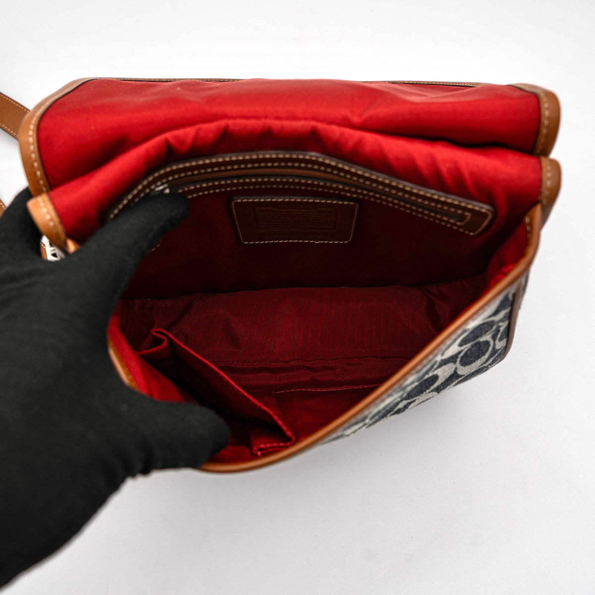 Coach signature denim hobo crossbody bag with red and blue stripe, brown leather trim, and an adjustable strap.