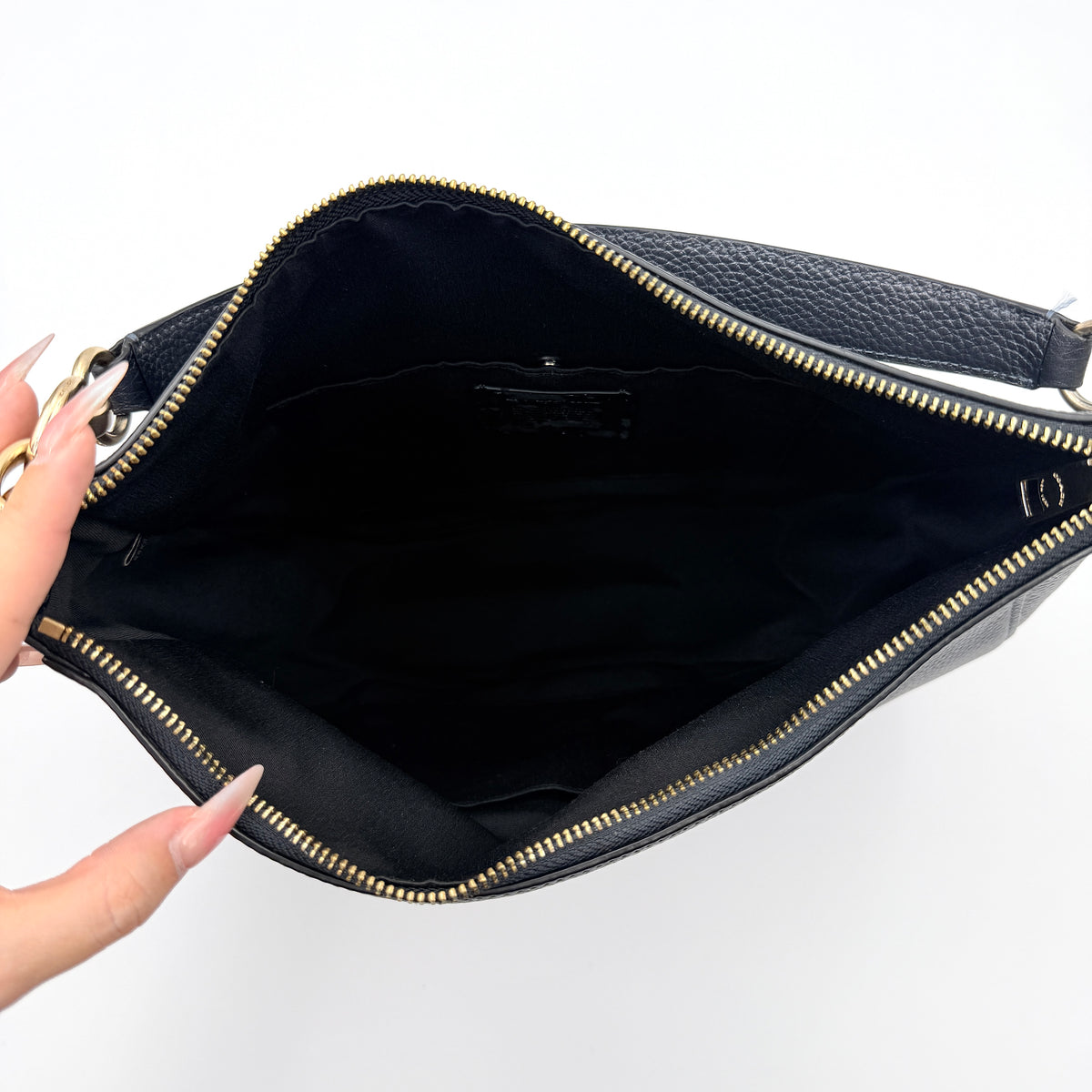 Coach Elle Hobo bag in navy blue pebbled leather with gold hardware and a detachable strap, styled on a white background.