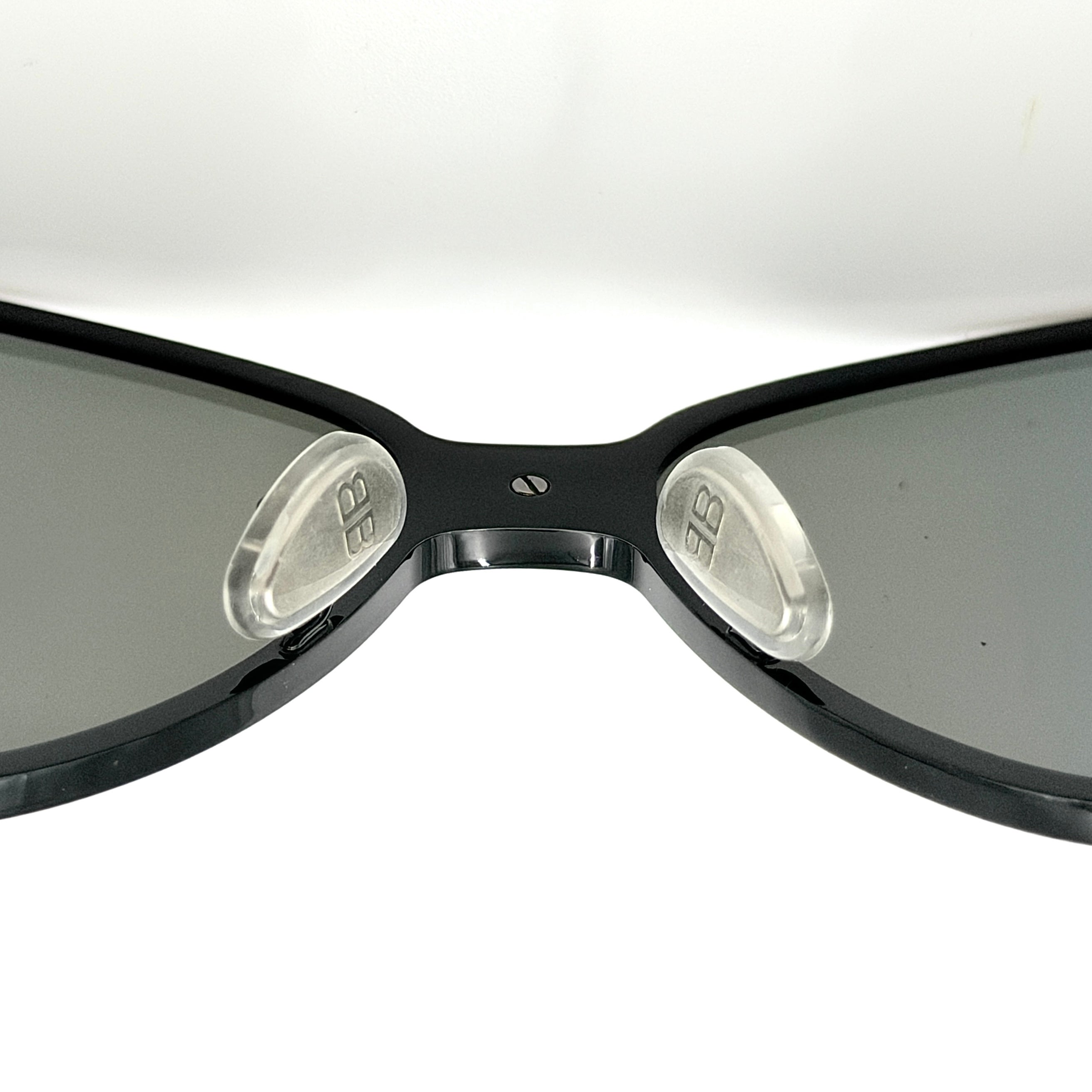Balenciaga cat-eye sunglasses with purple mirrored lenses and black frame, featuring signature BB logo at the bridge.