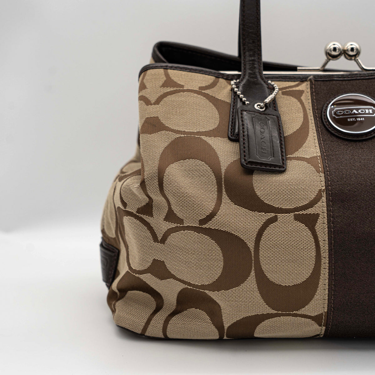Coach Signature Stripe Frame Kisslock Shoulder Bag in beige and brown canvas with leather trim and signature monogram pattern.