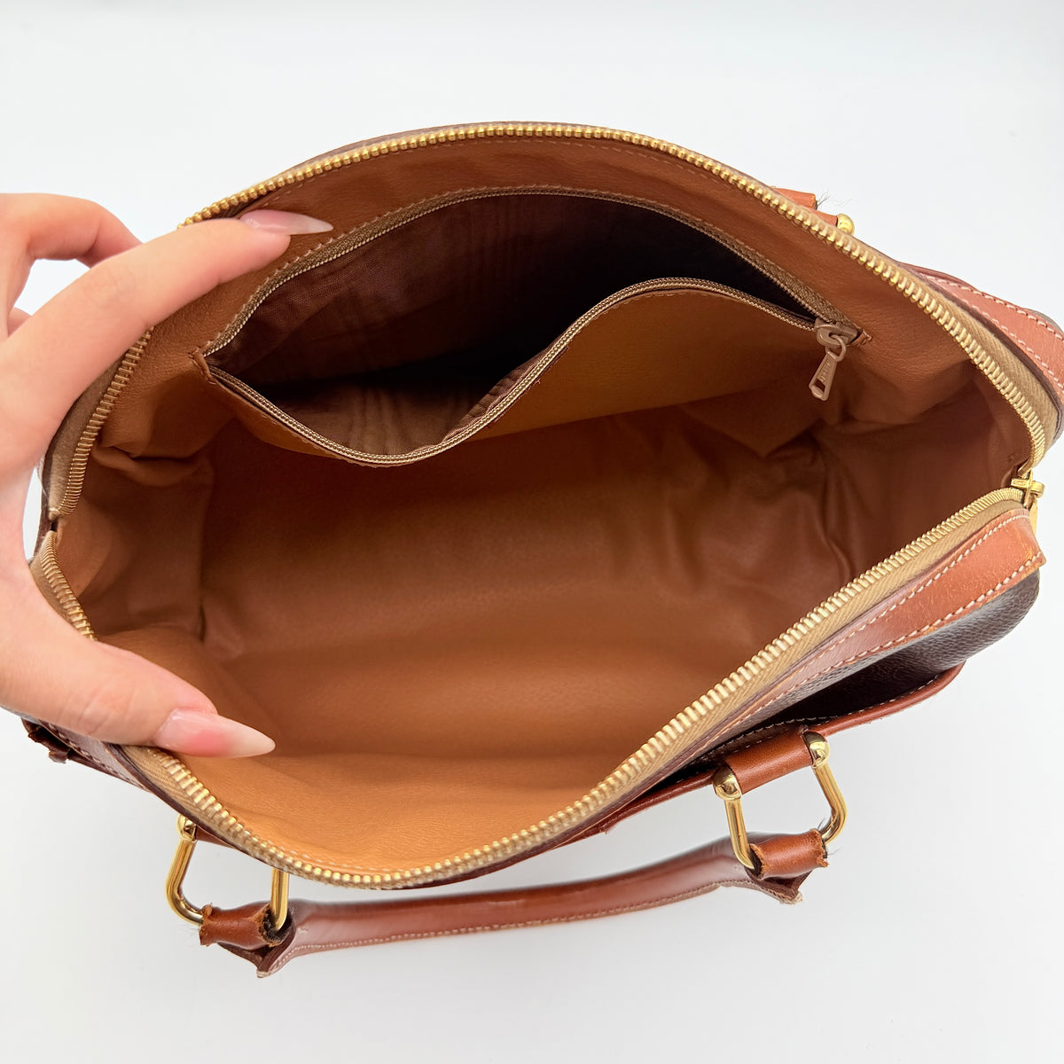 Celine Triomphe Macadam Boston Bag in brown coated canvas with tan leather handles and gold hardware on a white background.