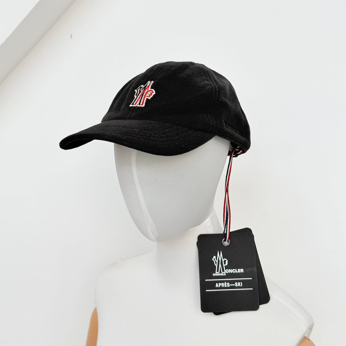Moncler Grenoble black fleece baseball cap with tri-colour logo patch on the front and tonal embroidery details.