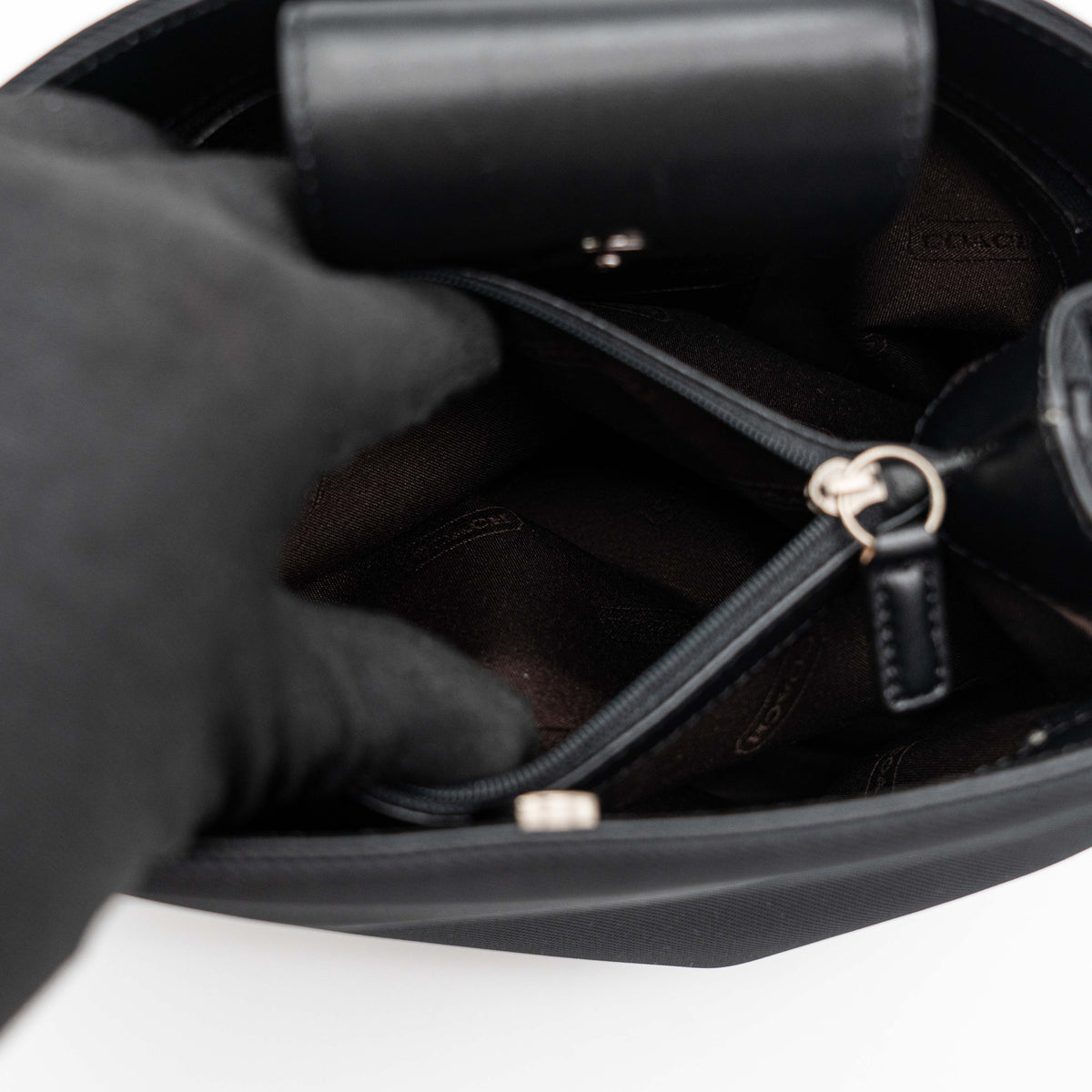 Coach Mercer tote bag in black nylon with leather handle and trim, presented against a white background.