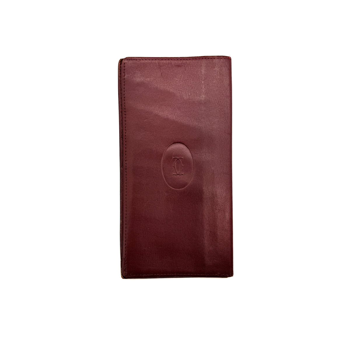Cartier Must de Cartier burgundy leather bifold long wallet with embossed logo and organized interior compartments.