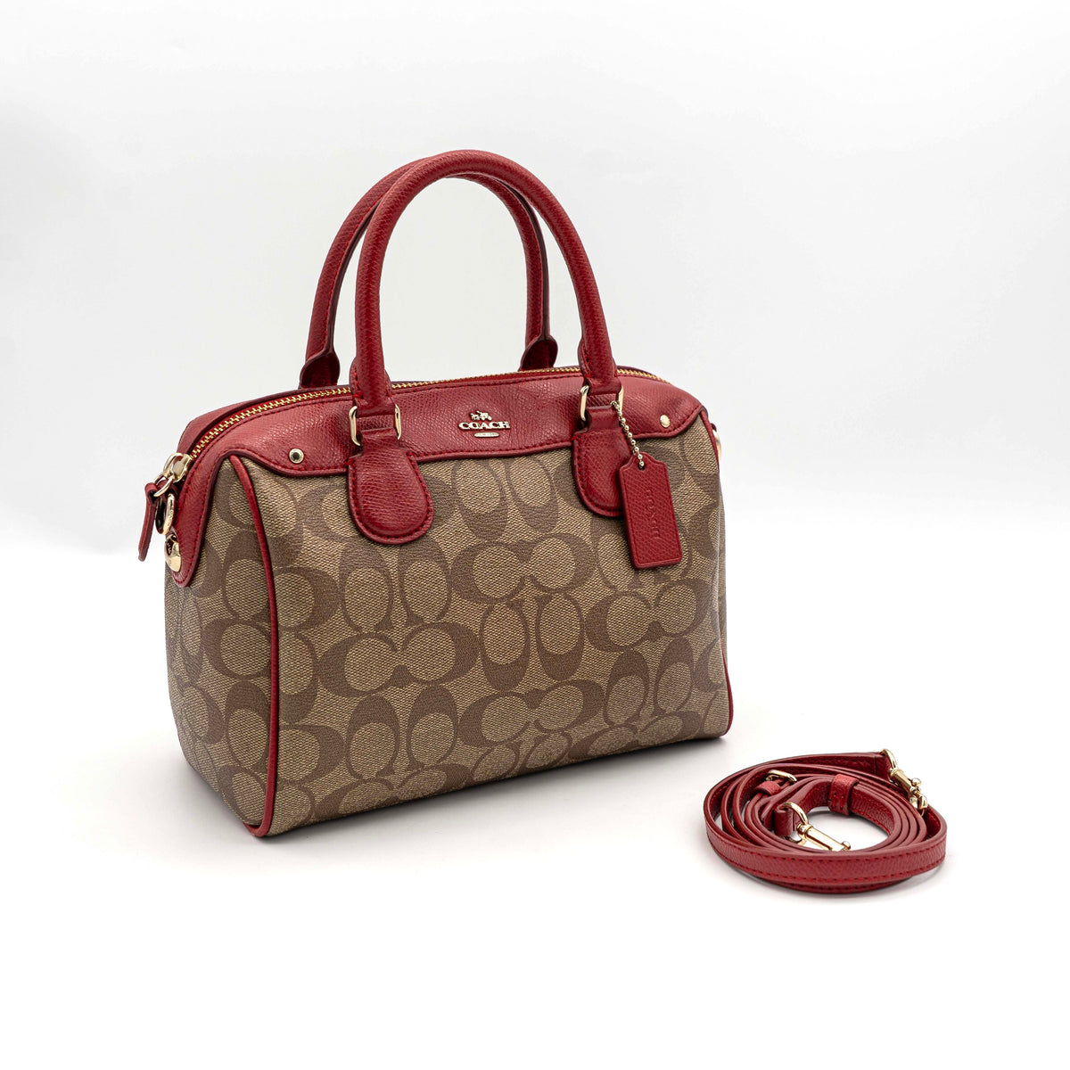 Coach Mini Bennett Boston bag in signature beige canvas with red leather trim, shown with detachable crossbody strap.