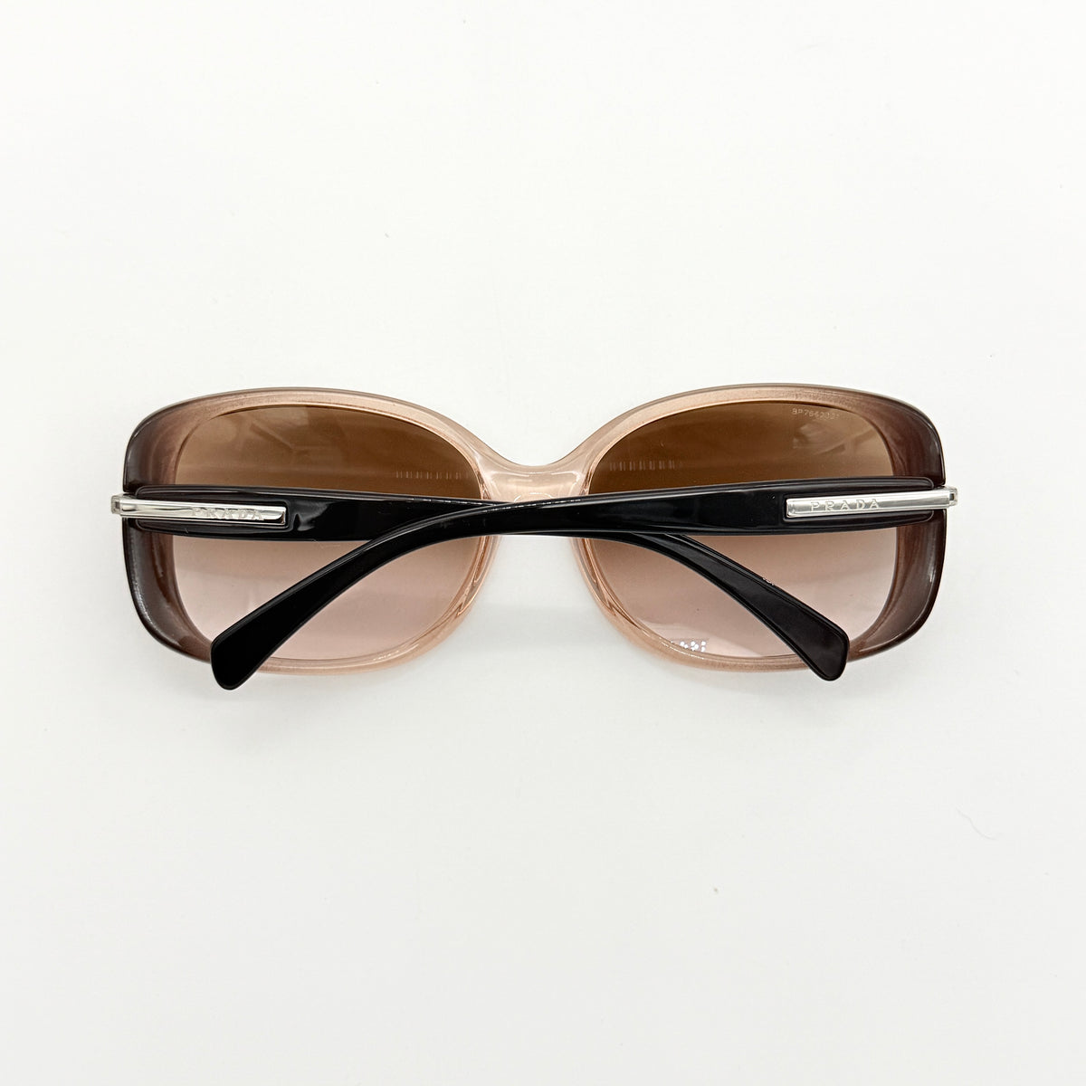 Prada SPR080 sunglasses featuring a brown and blush oversized frame with gradient lenses and silver hardware at the temples.