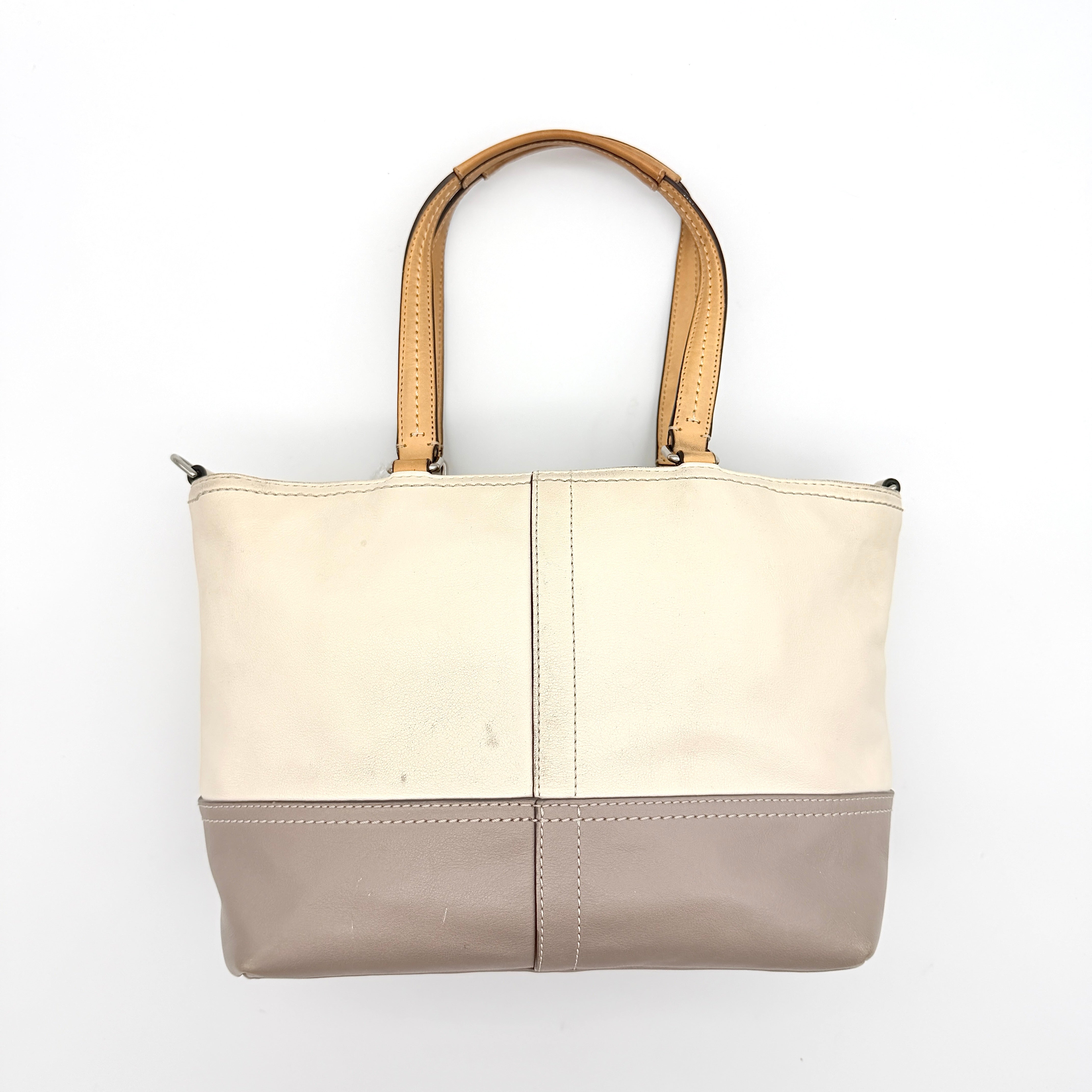 Coach Hampton Weekend perforated cream and grey leather tote bag with tan handles and a silver Coach charm, displayed against a white background.