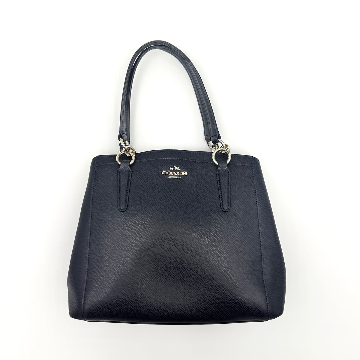 Coach Minetta Satchel in navy blue grained leather with dual handles and detachable shoulder strap displayed on a white background.