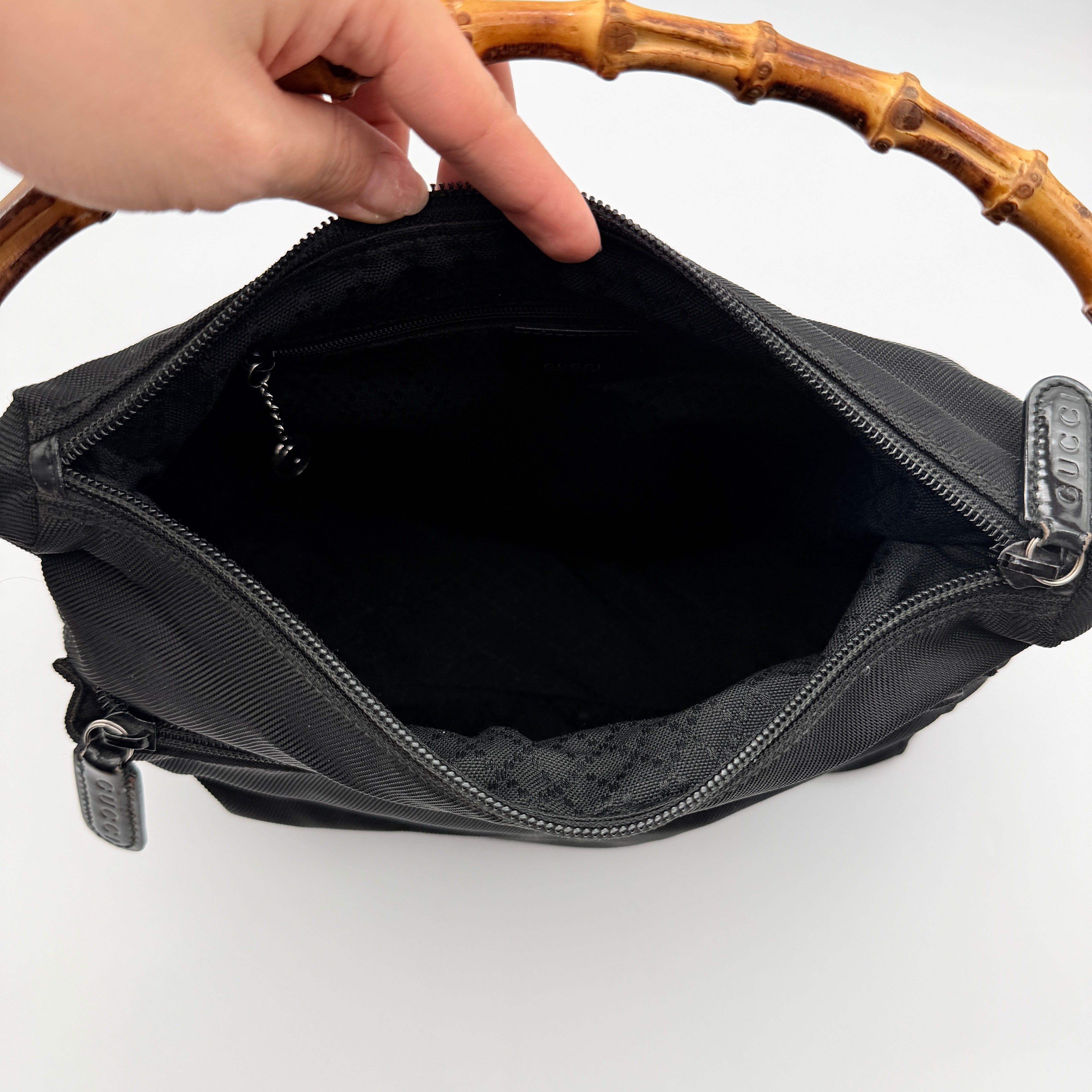 Gucci nylon shoulder bag in black with bamboo handle, shown against a white background.