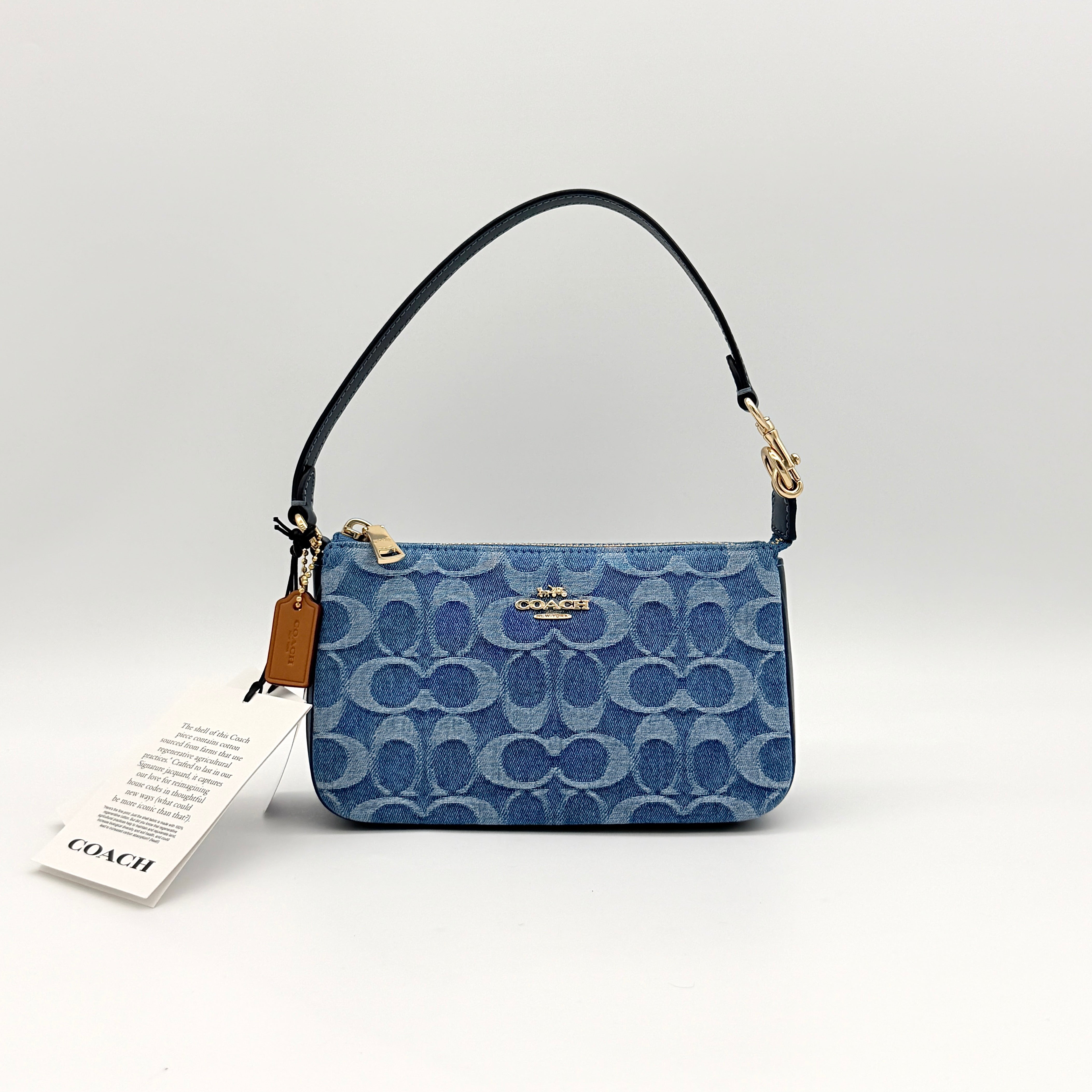Coach Nolita 19 shoulder bag in blue denim jacquard with monogram print and gold hardware, shown with original packaging.