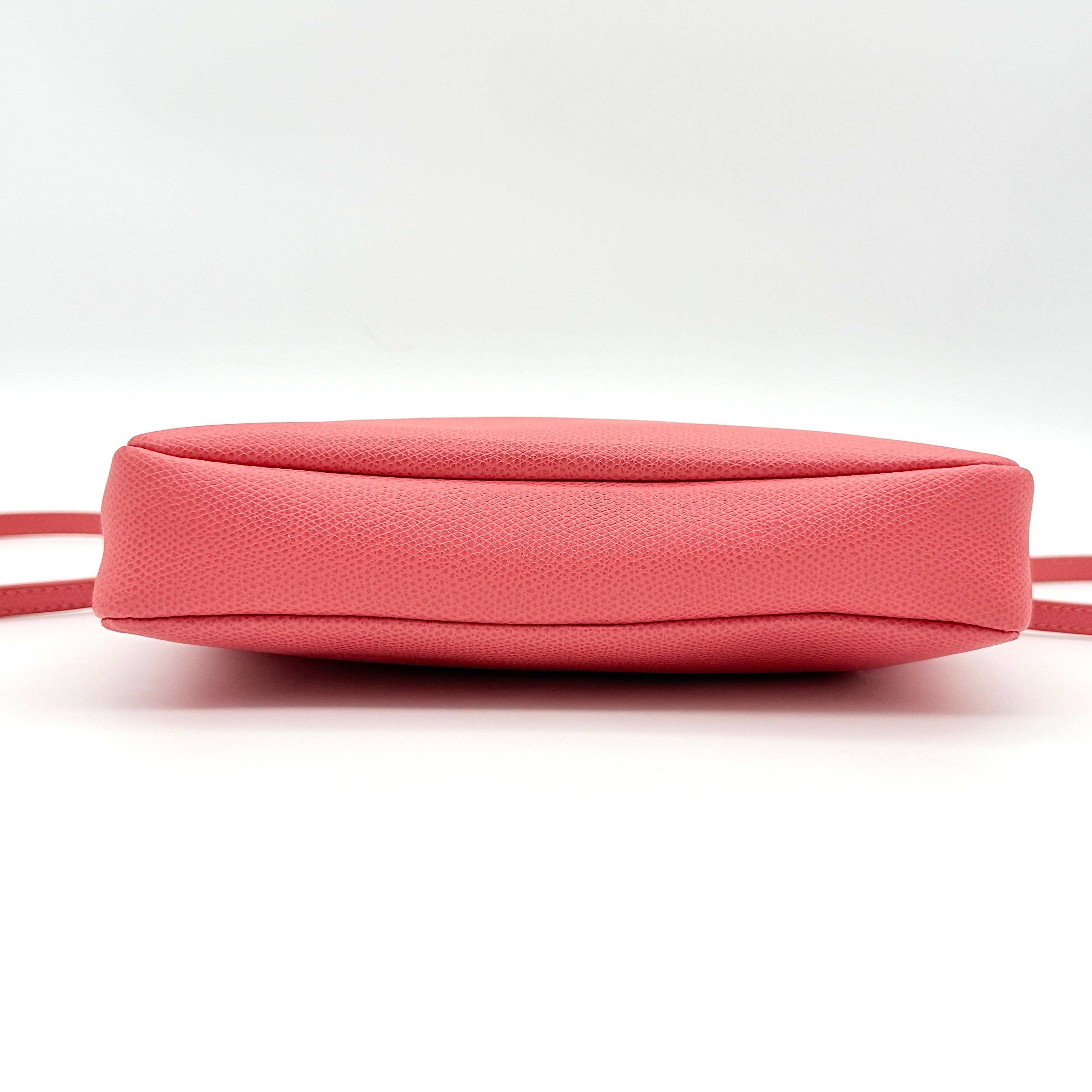 Furla pink leather crossbody bag with gold zip and adjustable strap, photographed flat on a white background.