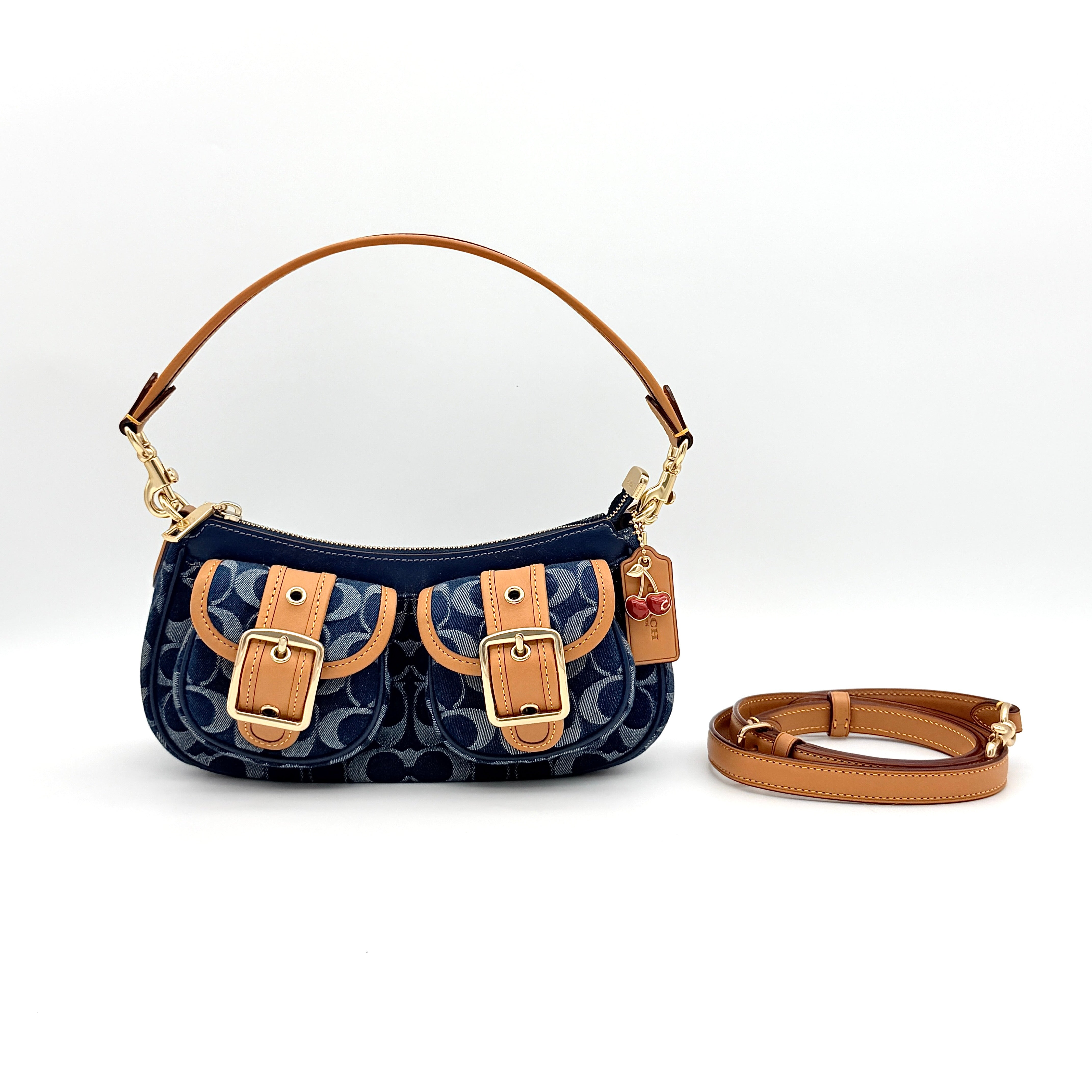 Coach Signature Ashton shoulder bag in blue denim and tan leather with gold hardware, shown with removable strap and dust bag.