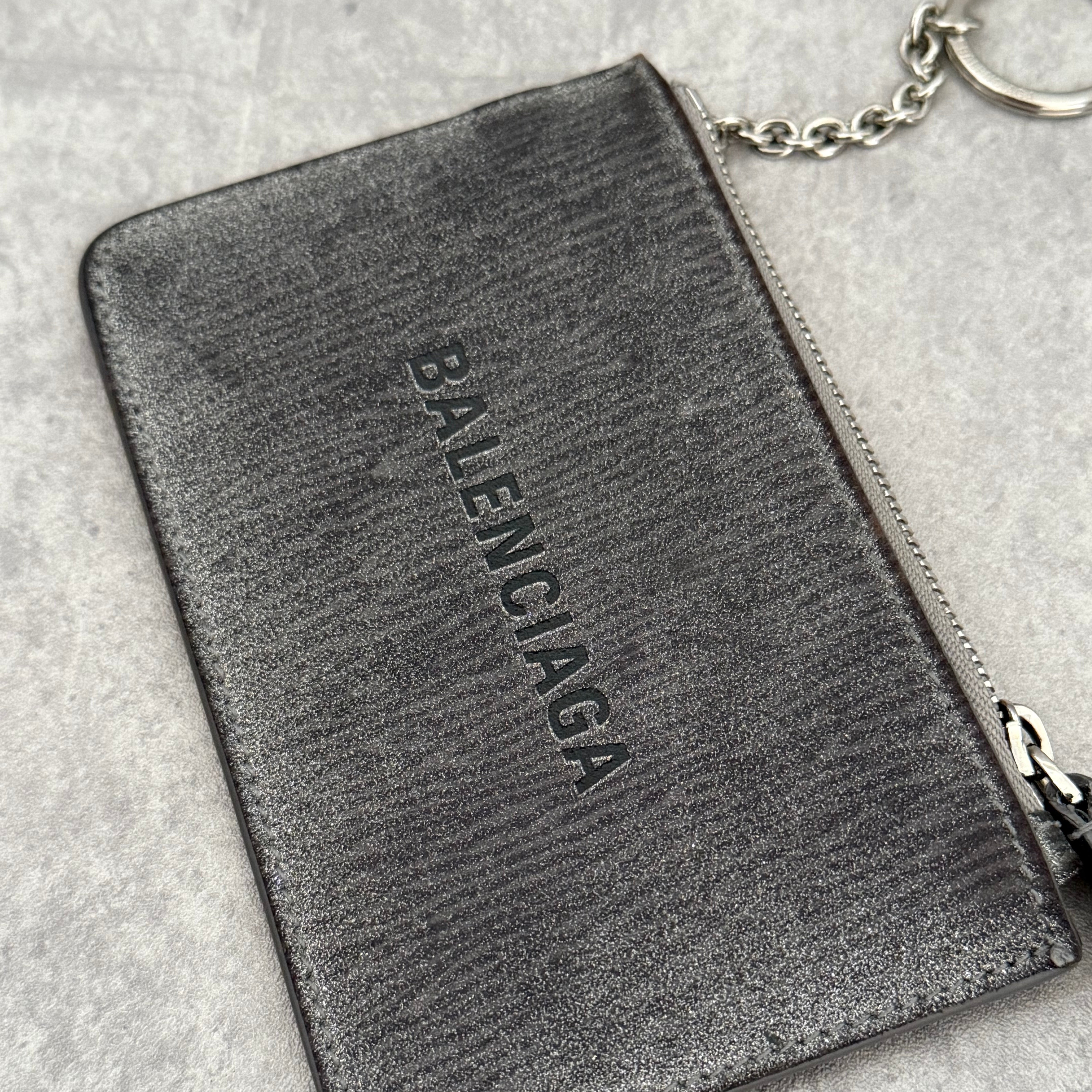 Balenciaga Graphic Print Silver Wallet, metallic silver leather with bold black logo and zip closure with keyring chain.