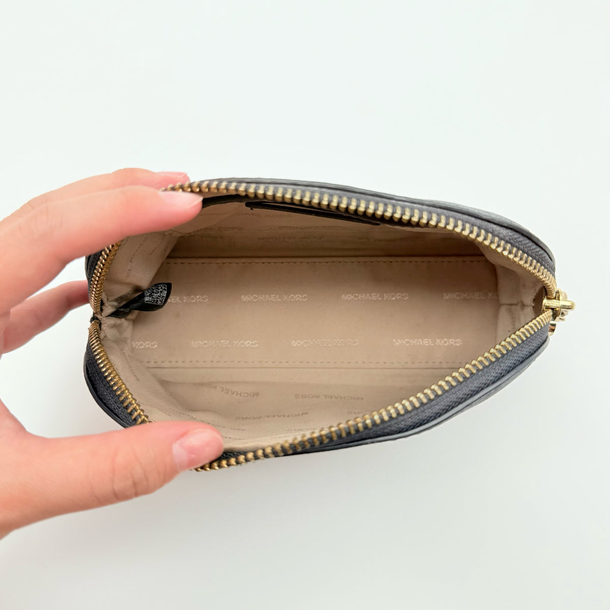 Front view of the Michael Kors black saffiano leather dome cosmetic pouch with gold-tone hardware.