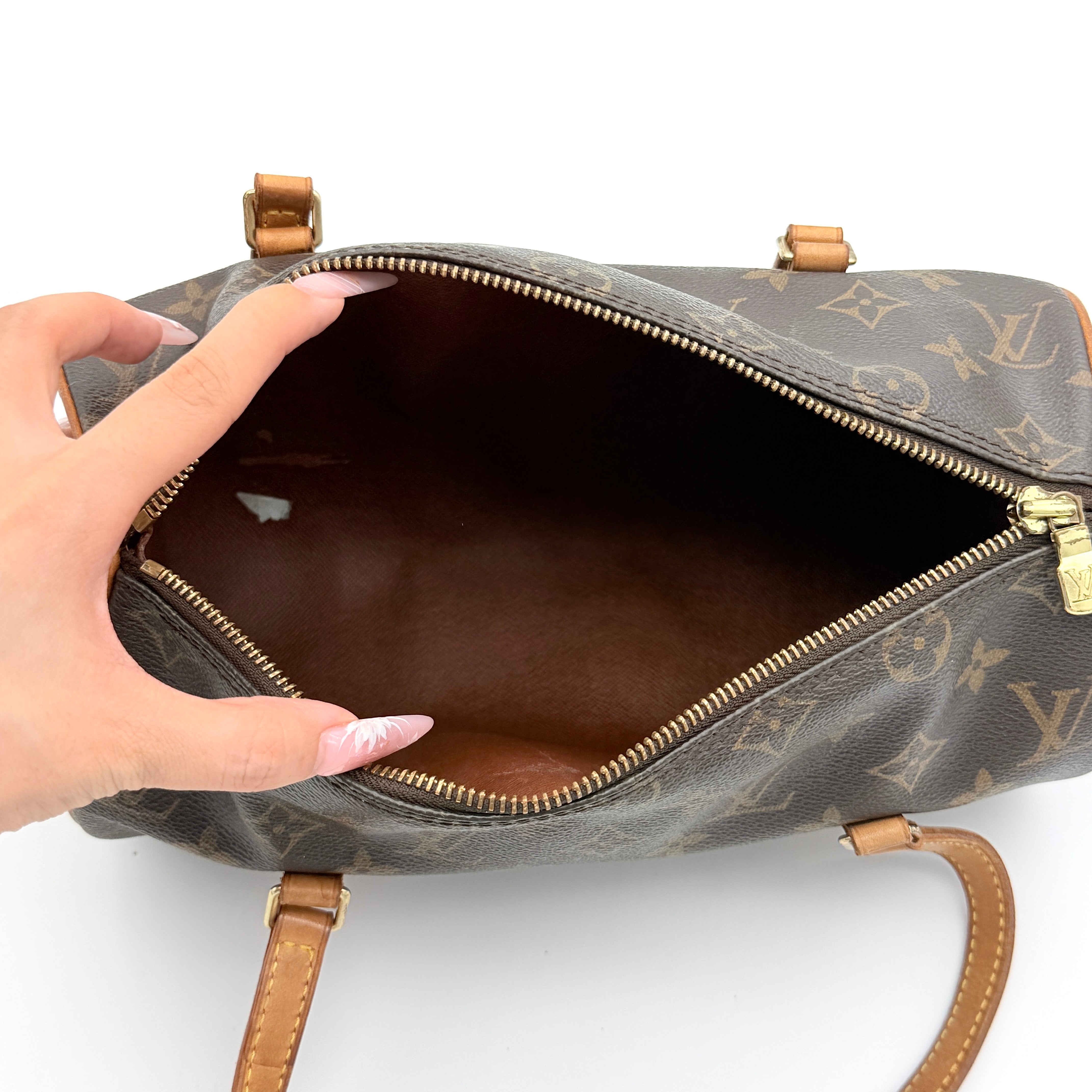 Louis Vuitton Papillon 26 in Monogram canvas with brown leather trim and gold-tone zip, shown against a white background.