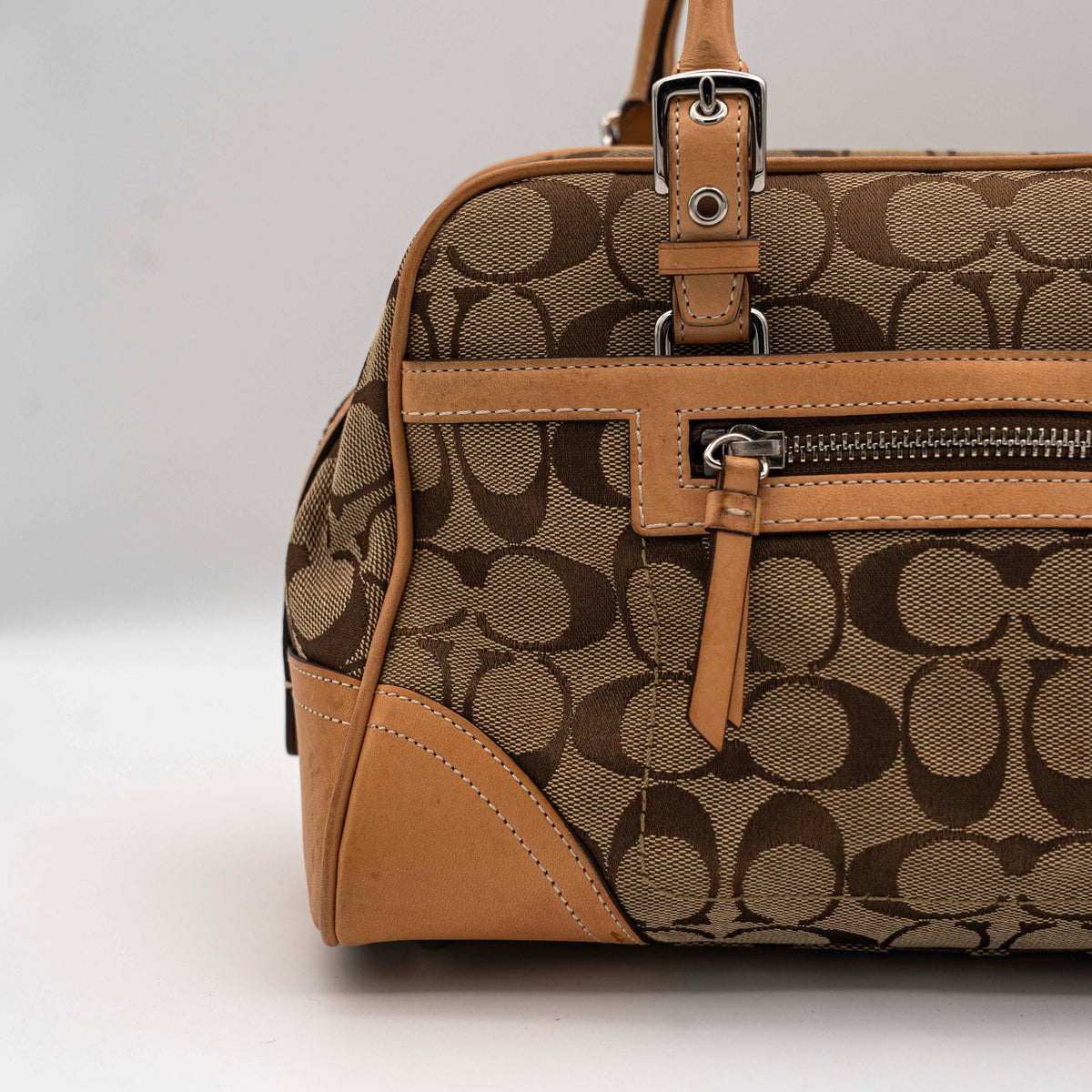 Coach Signature Hampton Satchel Boston Bag in beige and tan canvas with leather trim and silver hardware, styled on a clean background.