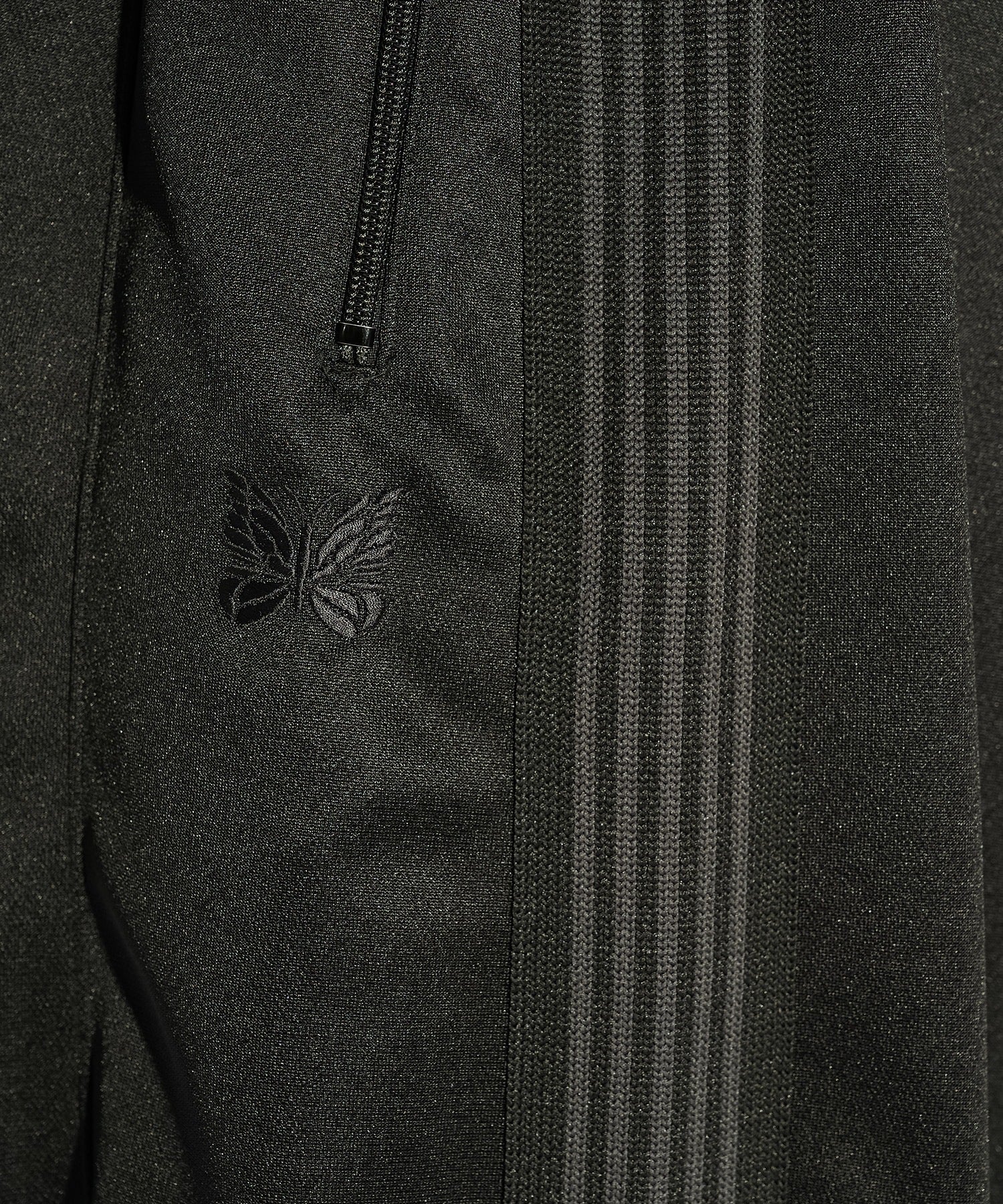 Needles H.D. Track Pant in black with tonal butterfly embroidery and relaxed wide-leg cut, photographed on model.