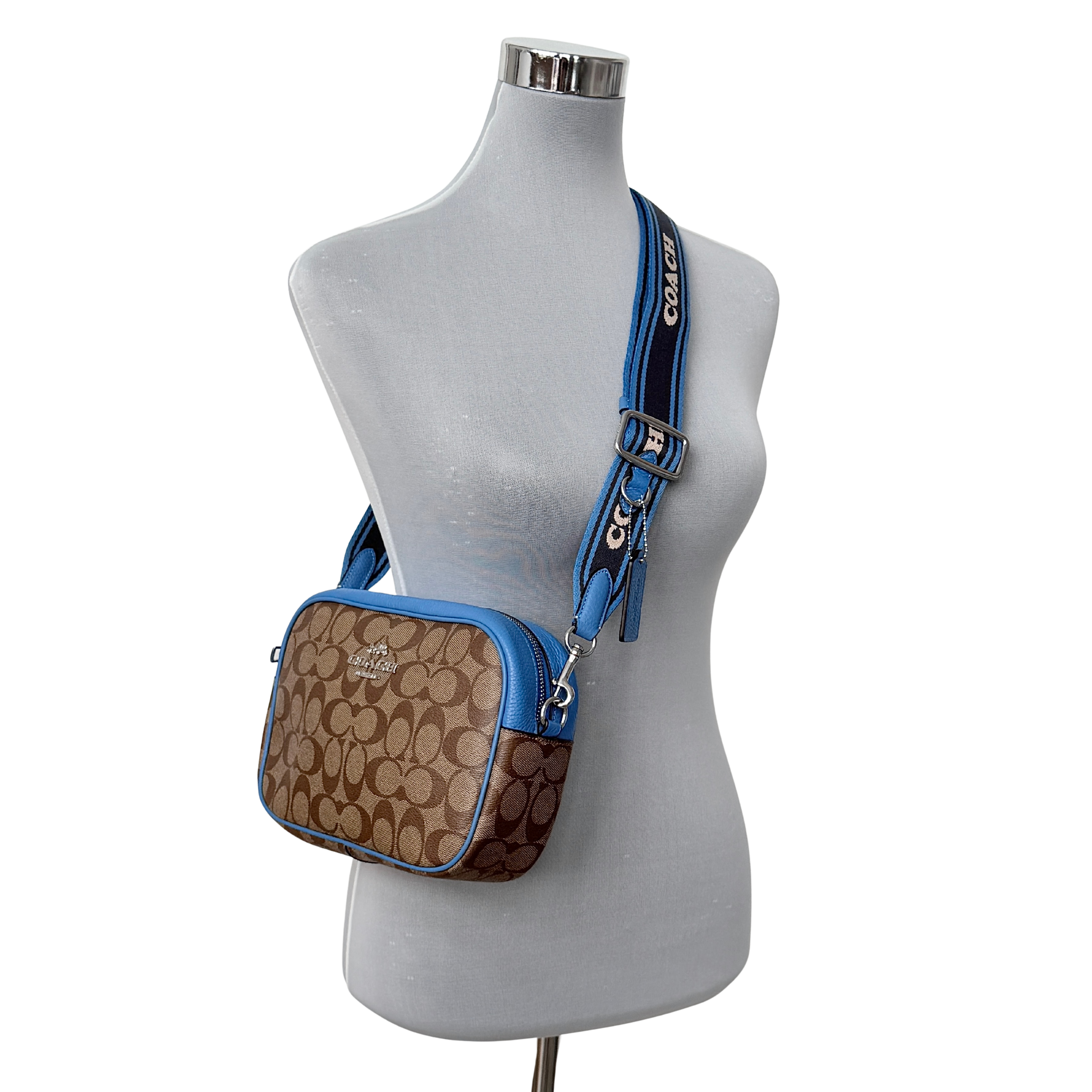 Coach Signature Jamie Crossbody Bag in beige and blue with bold logo webbing strap and blue leather trim, photographed against a white background.