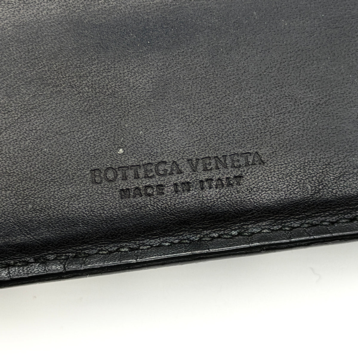 Bottega Veneta black Intrecciato woven leather wallet, shown closed against a white background.