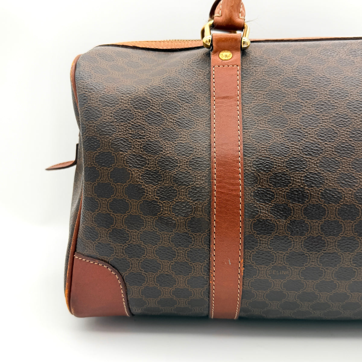 Celine Macadam Triomphe Boston Bag in brown coated canvas with tan leather and gold-tone hardware, shown against a white background.