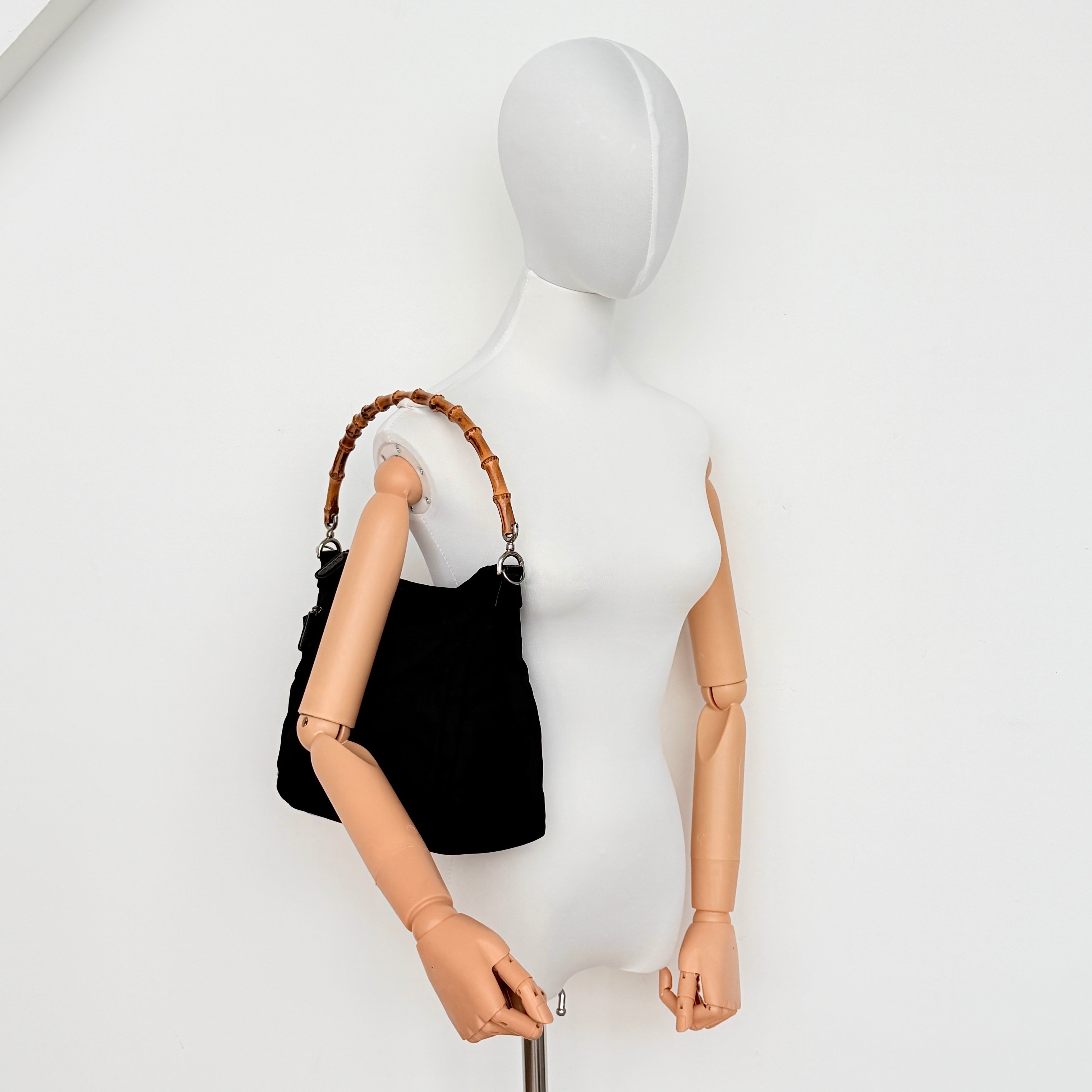 Gucci nylon shoulder bag in black with bamboo handle, shown against a white background.