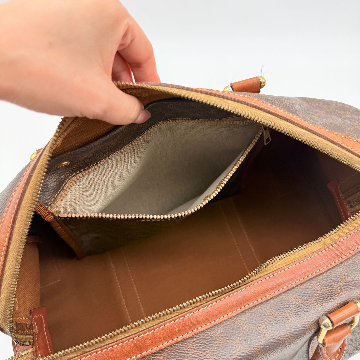 Celine Macadam Triomphe Boston Bag in brown coated canvas with tan leather and gold-tone hardware, shown against a white background.