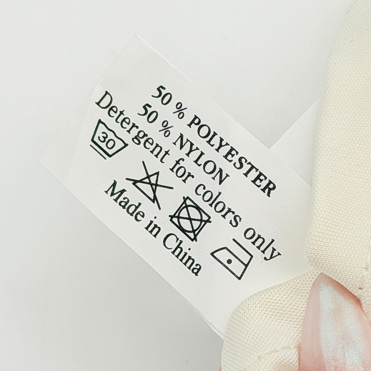 Pair of Cartier ivory gloves with signature script logo embroidery displayed on a flat white background.