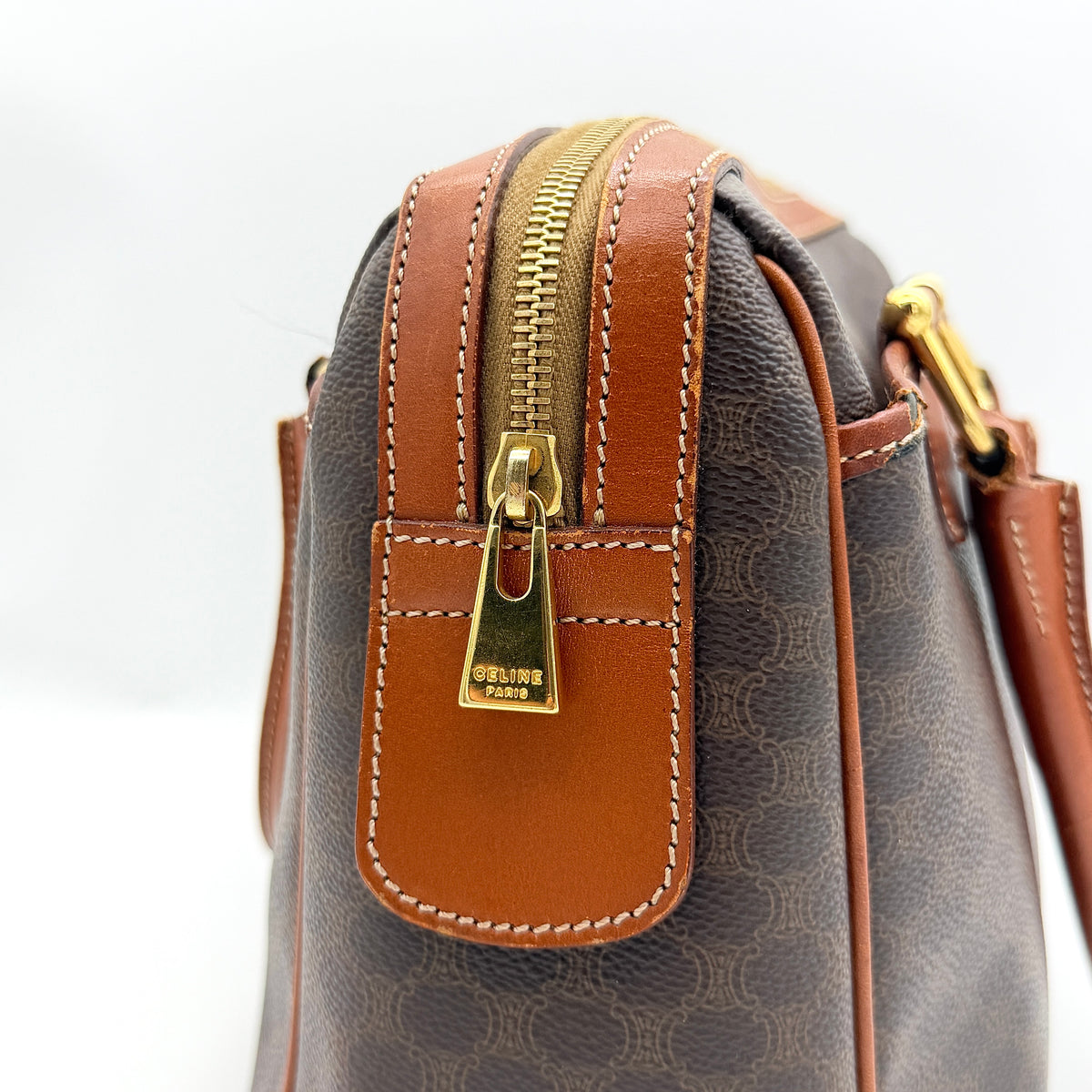 Celine Triomphe Macadam Boston Bag in brown coated canvas with tan leather handles and gold hardware on a white background.