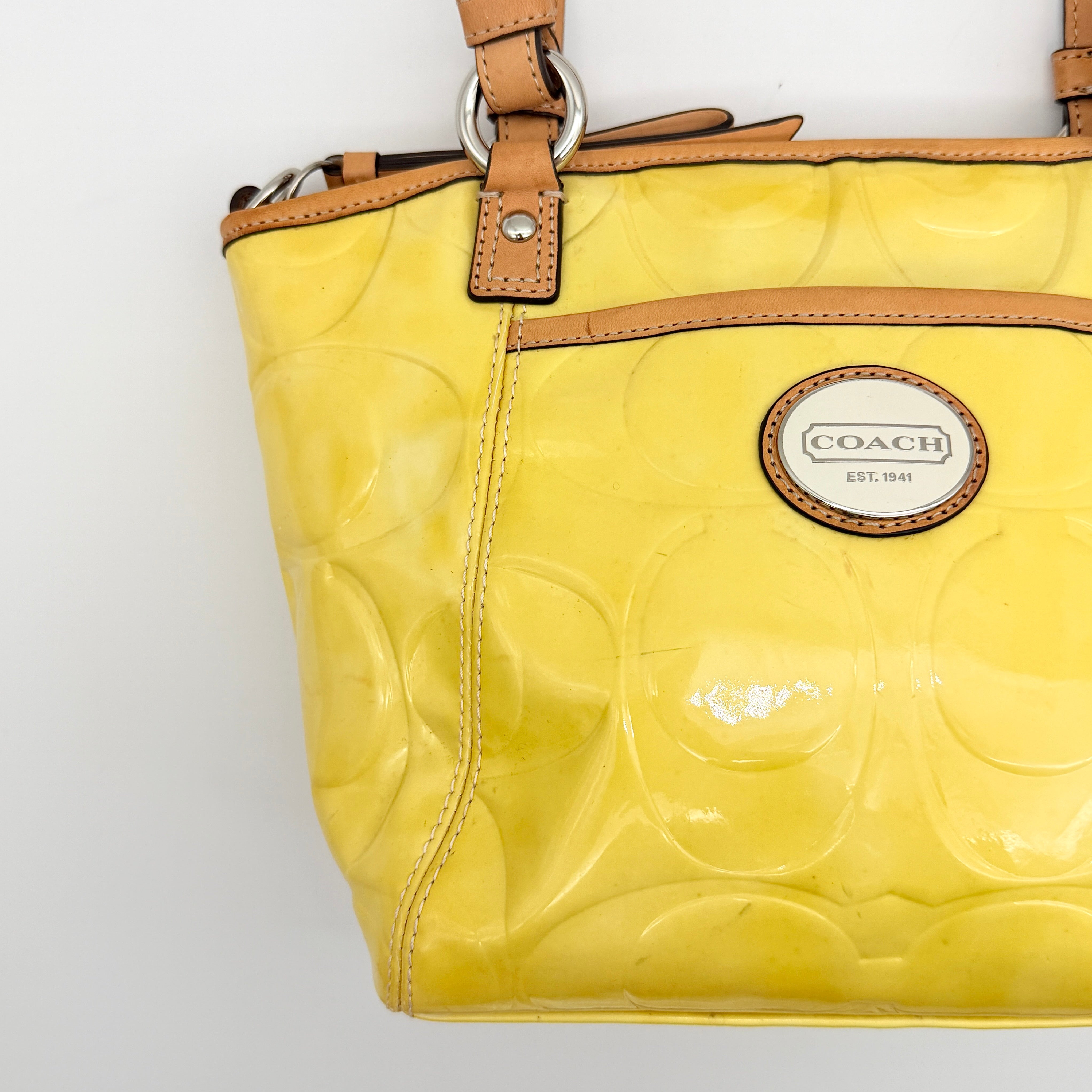 Coach Peyton tote in glossy yellow patent leather with tan handles and detachable strap, shown with blush pink interior.