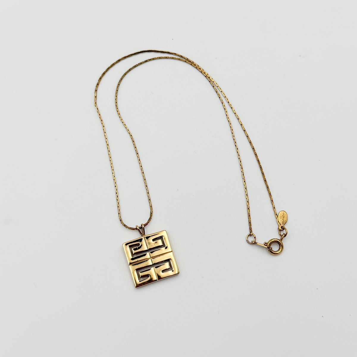 Givenchy 4G Logo Necklace in polished gold-tone metal with a geometric pendant on a fine chain.